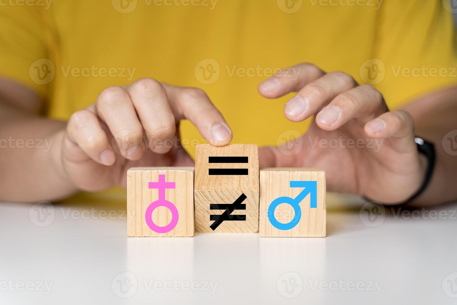 A hand changes an unequal sign to an equal sign between male and female symbols. photo