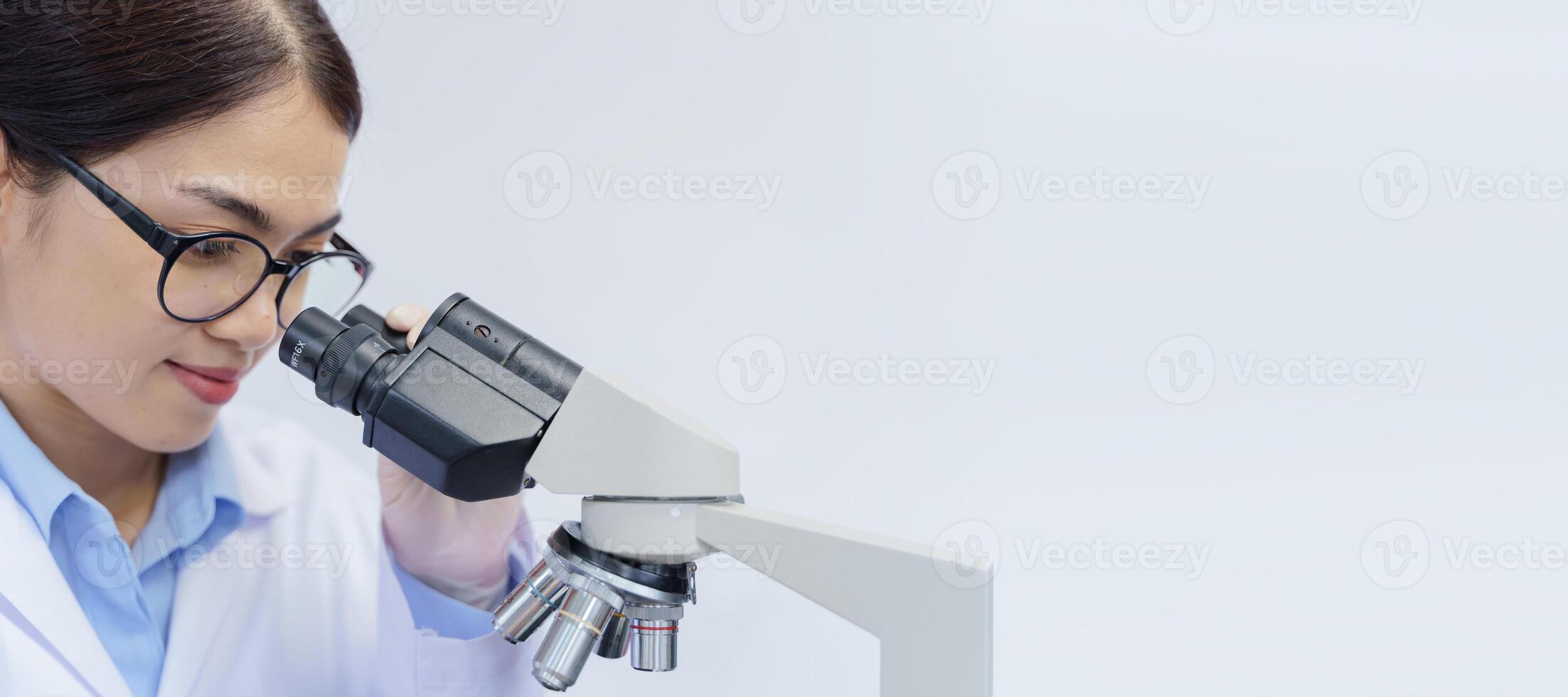 Scientist researcher using laboratory microscope, medical healthcare technology and pharmaceutical research and development concept. photo