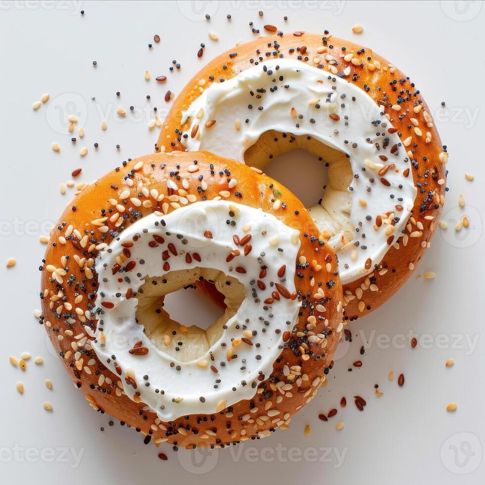 two bagels with frosting and sprinkles on a white photo