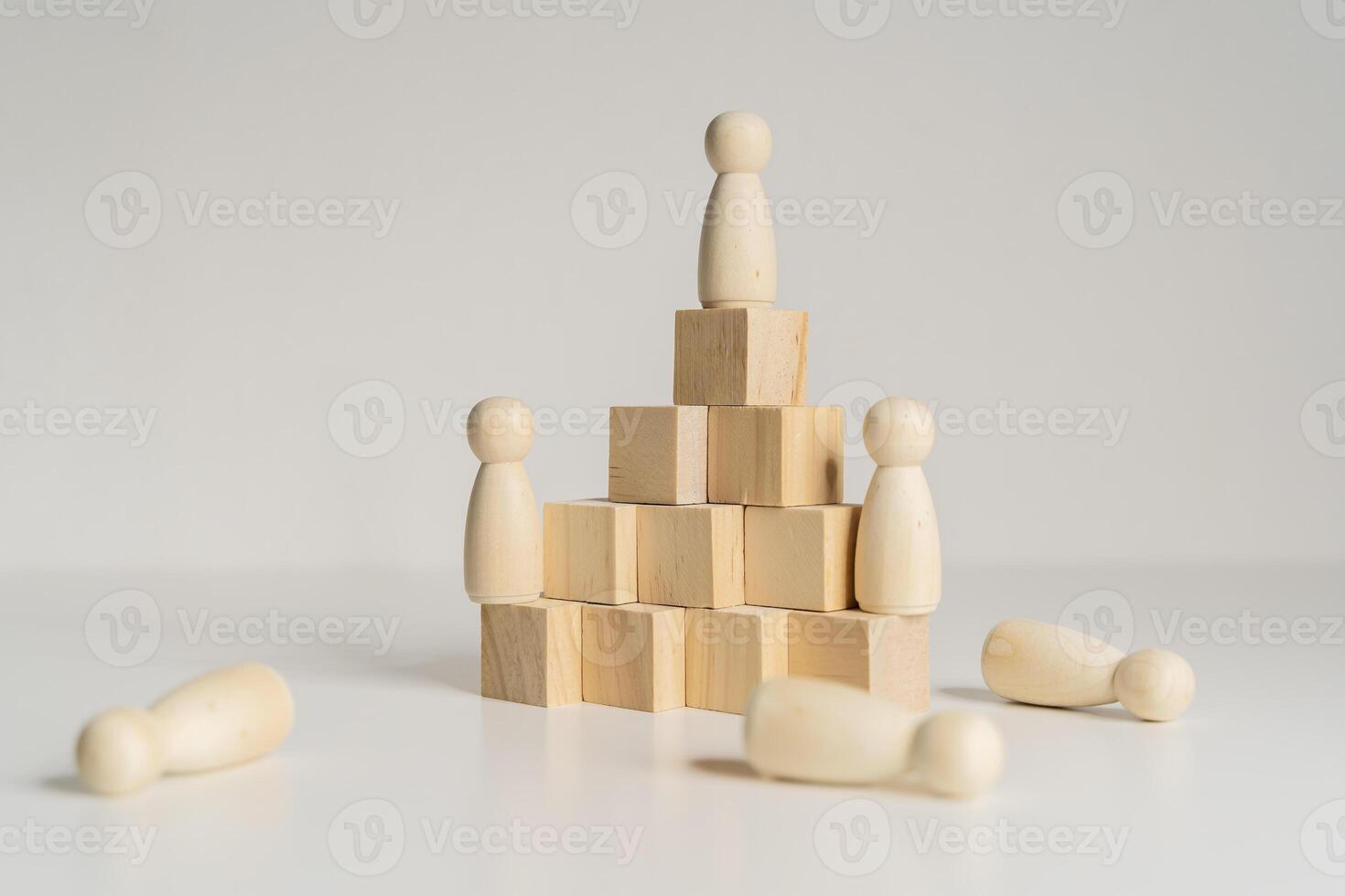 A wooden figure stands on top of three wooden blocks. The blocks are stacked on top of each other photo