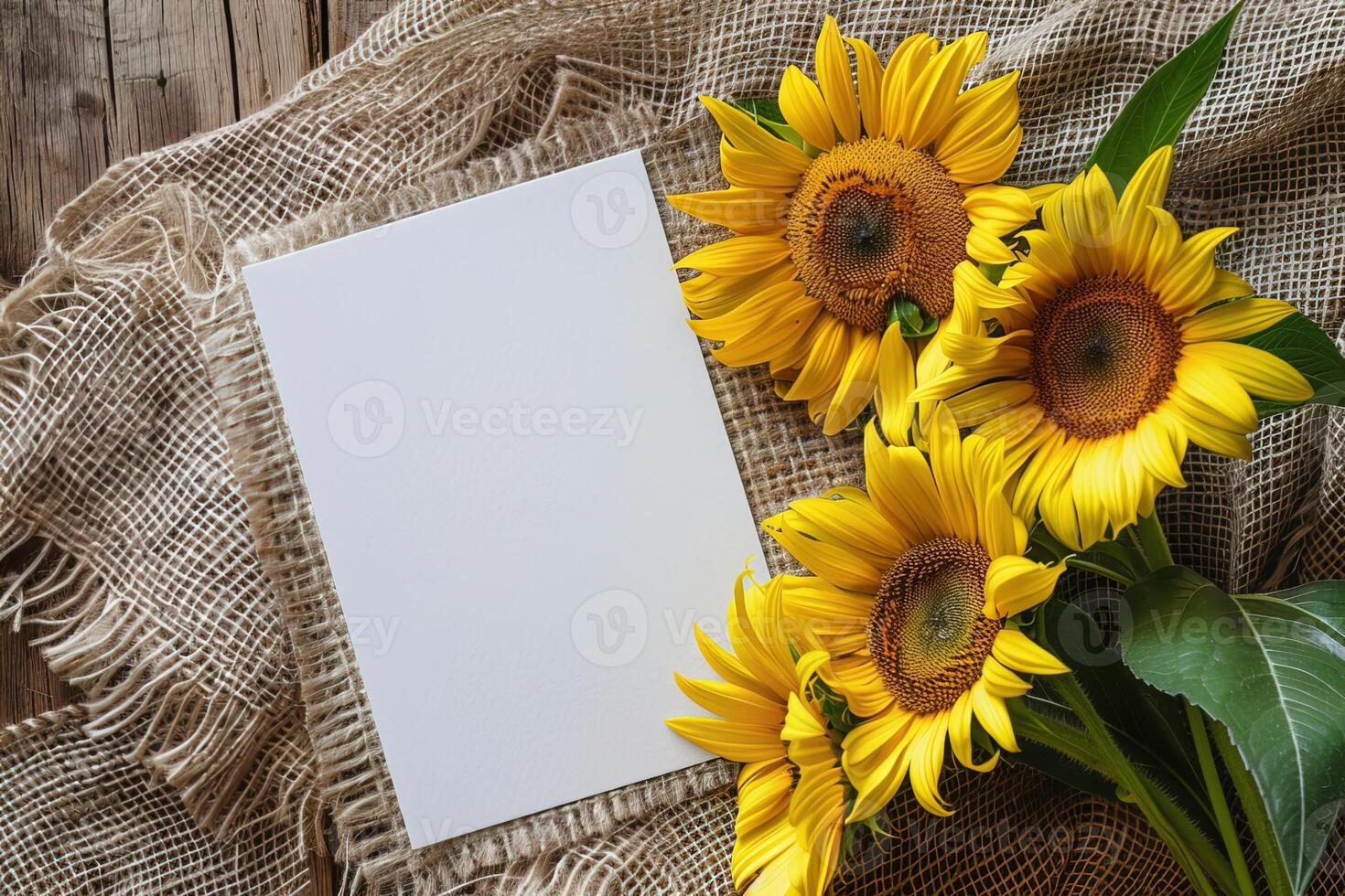 mockup bouquet sunflowers and white empty card on burlap fabric on rustic wooden background top view photo