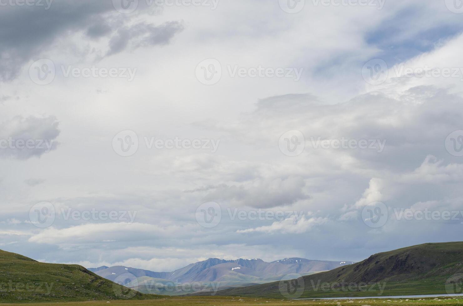 Mountain slopes with clouds on the sky covered with valley on top and mountains in Altay Russia early in the evening sunset. Hight quality horizontal photo