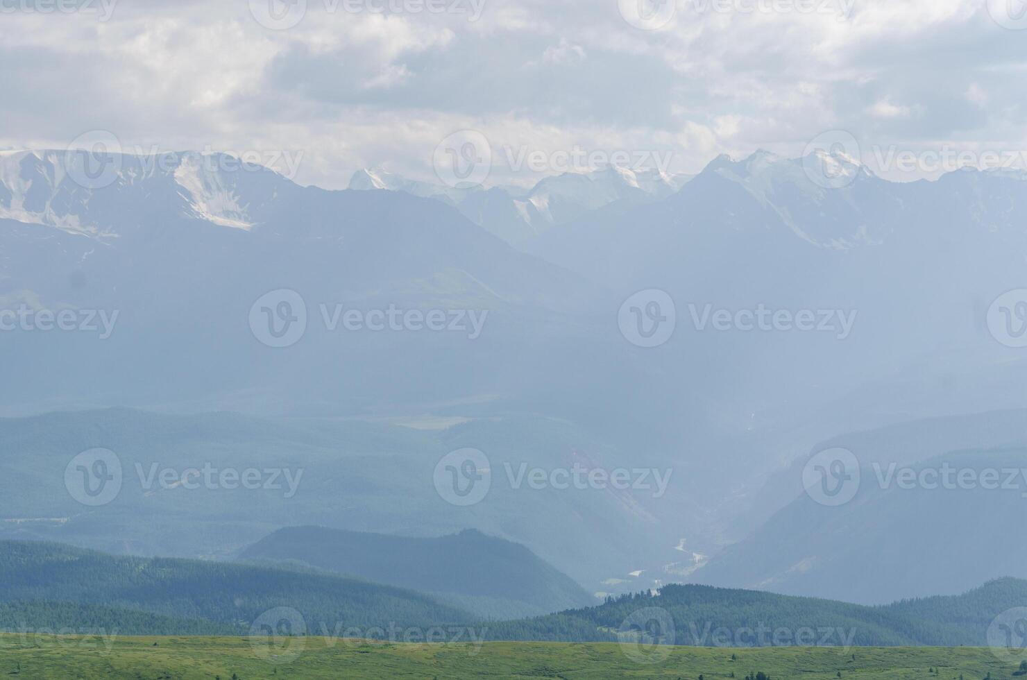 Mountain slopes in haze with rocks covered with valley on top and mountains in Altay Russia early in the evening sunset. Hight quality horizontal photo