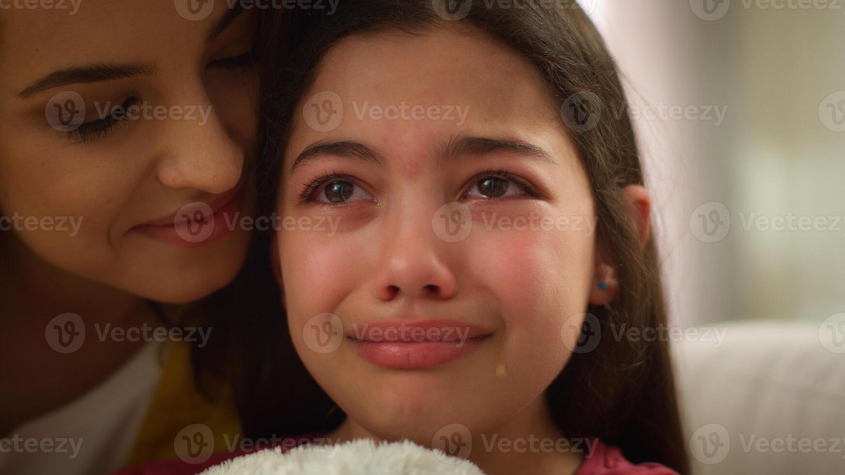 Loving Caucasian woman female caring mother sister tender parent soothing hug embrace cuddle sad little girl crying kid mom comforting child daughter cry inside living room. Happy family relationship photo