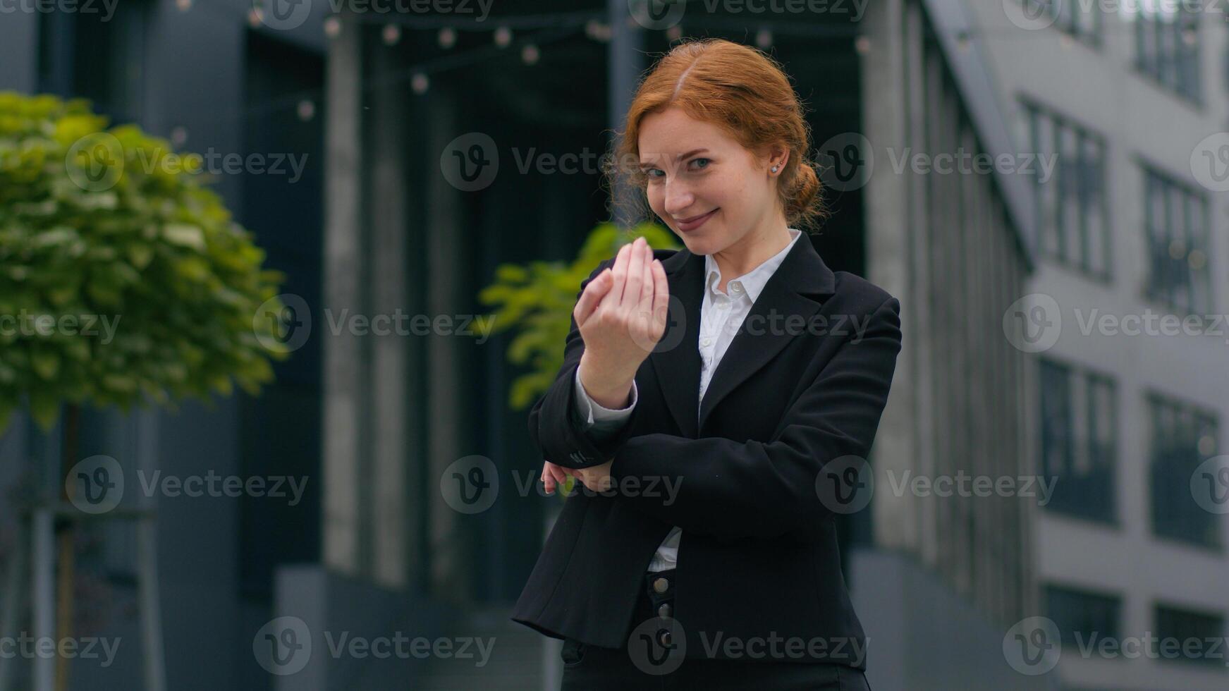 Happy friendly smiling young Caucasian ginger businesswoman recruiter girl female woman crossed arms formal suit welcome invite wave hand welcoming join invitation gesture outside city office building photo