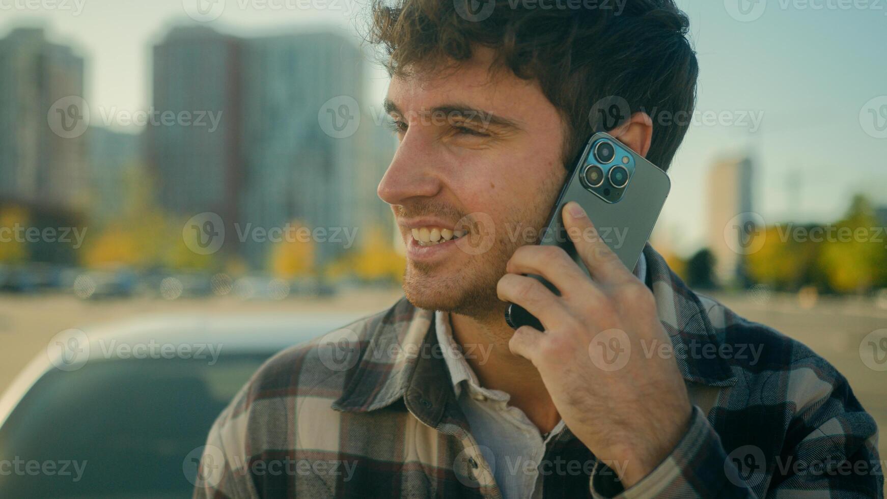 Smiling guy handsome 30s Caucasian man driver talk mobile phone with auto car background on parking happy male successful businessman calling smartphone friendly conversation in city urban lifestyle photo
