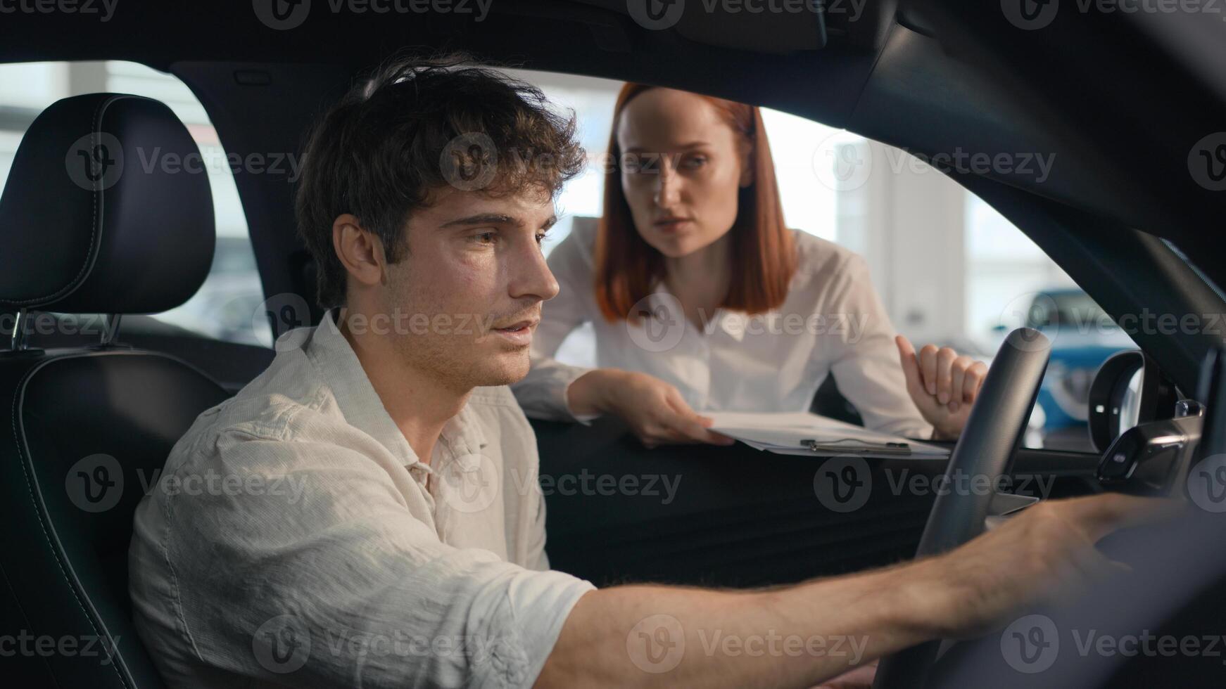 Caucasian seller woman female automobile salon manager trader saleswoman consult client male buyer man helping businessman choose auto explain trade new car to customer male sit inside vehicle rent photo
