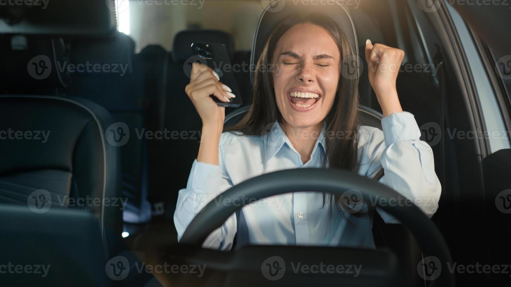 Caucasian businesswoman happy excited girl business woman successful winner female driver in car automobile win mobile phone success achievement victory in auto smartphone winning yelling joyful prize photo