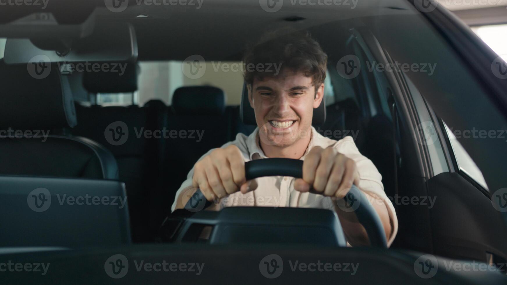 Happy Caucasian man driving new luxury electric crossover car in automobile salon dealership rejoice buy celebrate sitting inside cab auto transport credit loan emotions of happiness buyer achieve photo