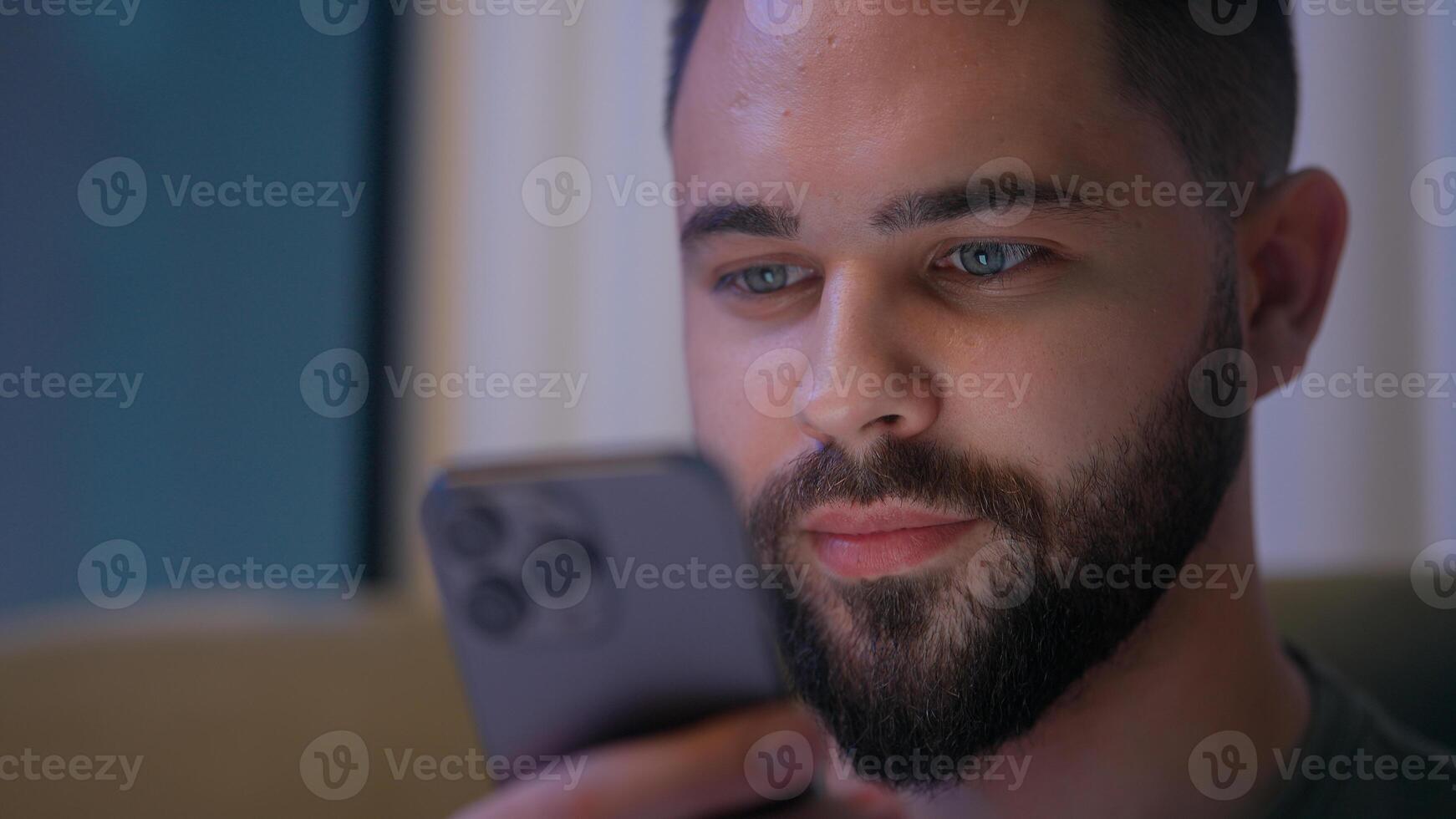 Close up face Caucasian man user mobile phone smartphone cellphone guy male late night gadget cyber ecommerce touchscreen network online distance connect eyes vision unhealthy insomnia addicted stuck photo