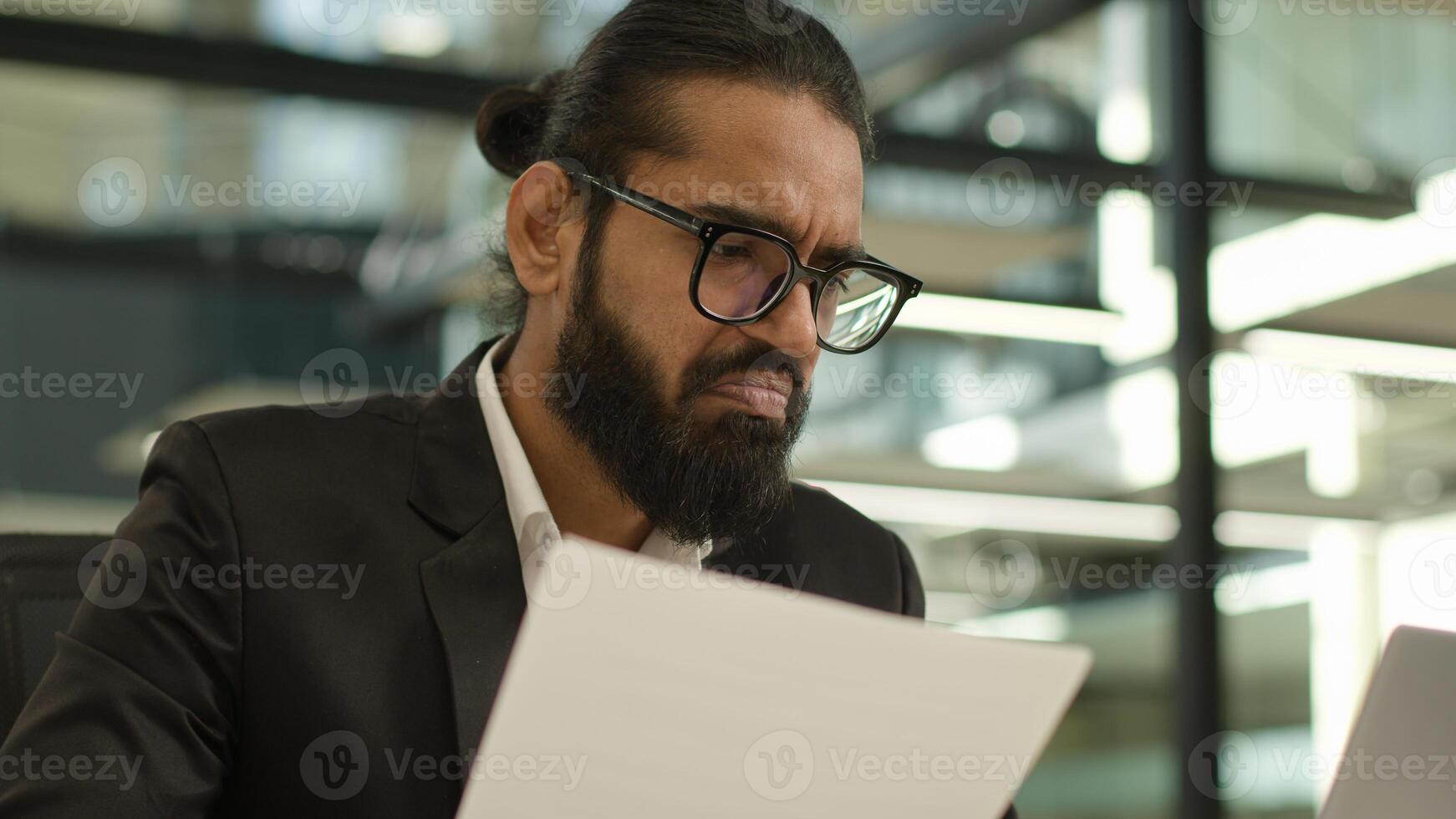 Arabian Muslim business man Indian businessman employer entrepreneur manager confused with papers and laptop in office problem paperwork bad result talking call working with documents failure photo