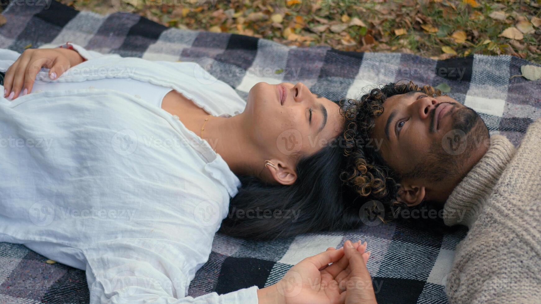 Indian Arabian couple in love boyfriend girlfriend talking smiling enjoying tenderness closeness man woman girl guy husband wife married talk communicate lying relaxing in park autumn dating outdoors photo