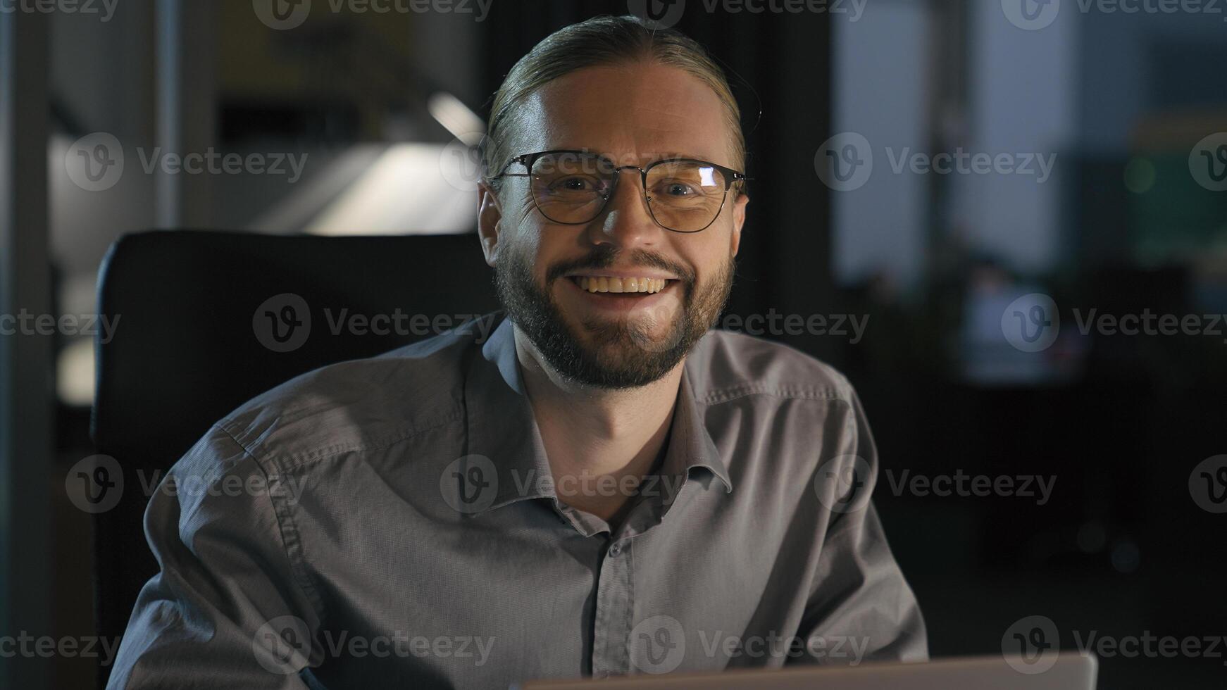 Caucasian emotional ecstatic excited businessman trader salesman business man employer office worker winner at night evening workplace win laptop online good result financial growth achieve success photo