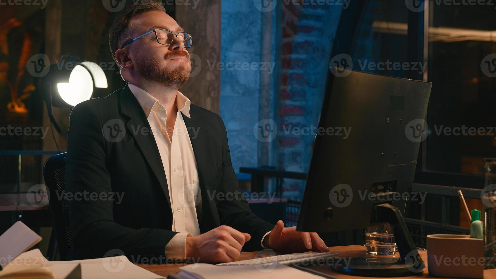 Caucasian busy businessman tired worker guy business man male employer fatigued exhausted overworked entrepreneur work online computer at night overtime office look at wristwatch check time deadline photo