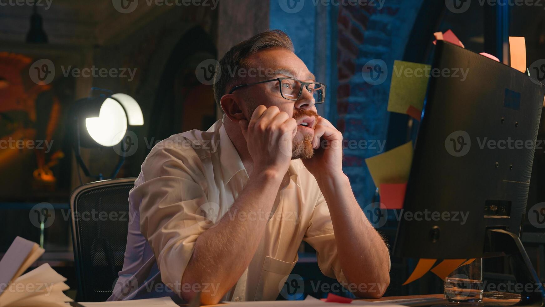 Stressed frustrated business man at night office overworked trouble problem businessman male guy looking at monitor screen sticky notes with writing many tasks on computer tired exhausted headache photo