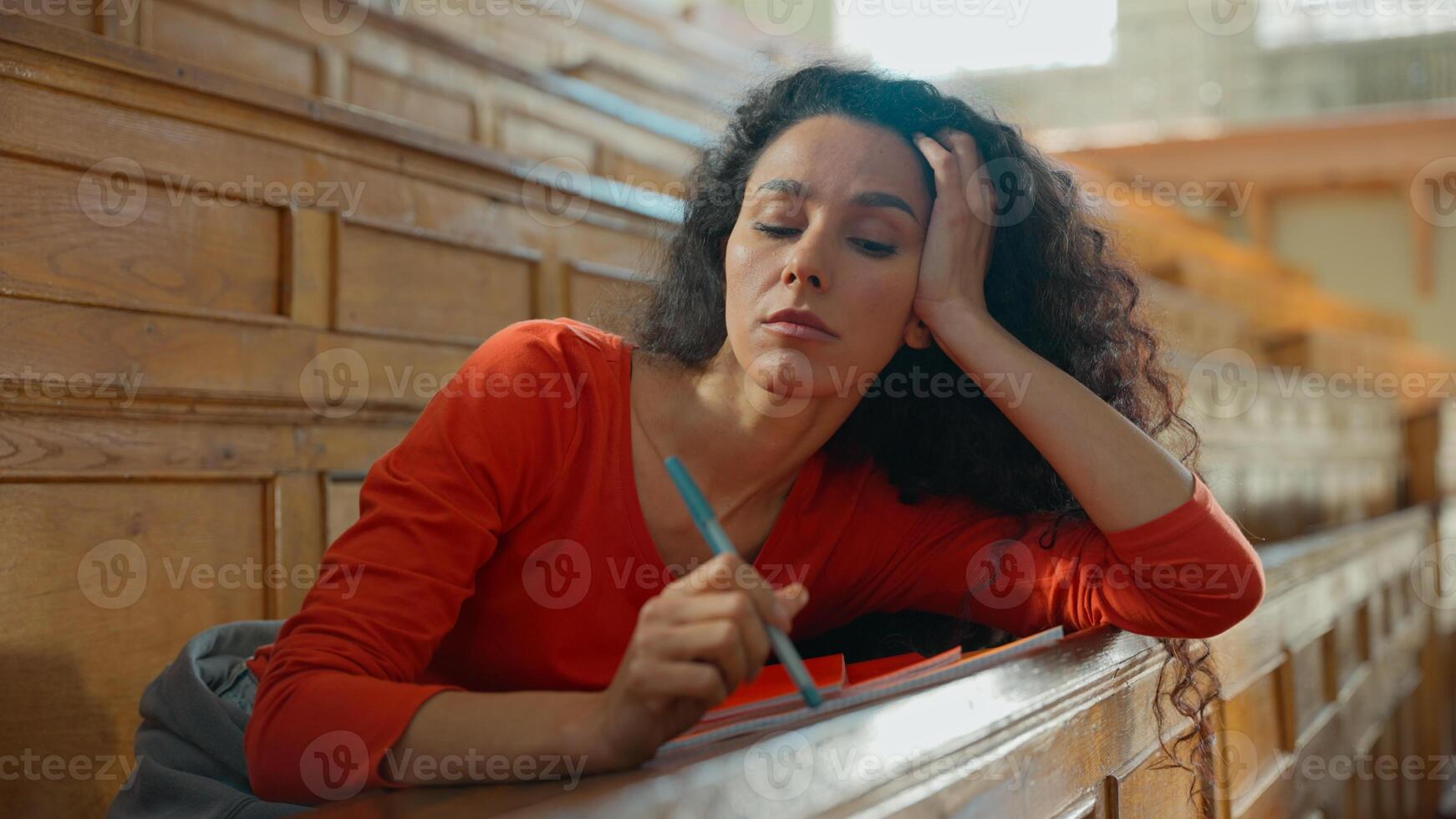 Pensive thinking boring lazy Hispanic woman thoughtful sad Latina girl student female lady study at table copybook college university academy auditorium lecture course studying learning boredom class photo