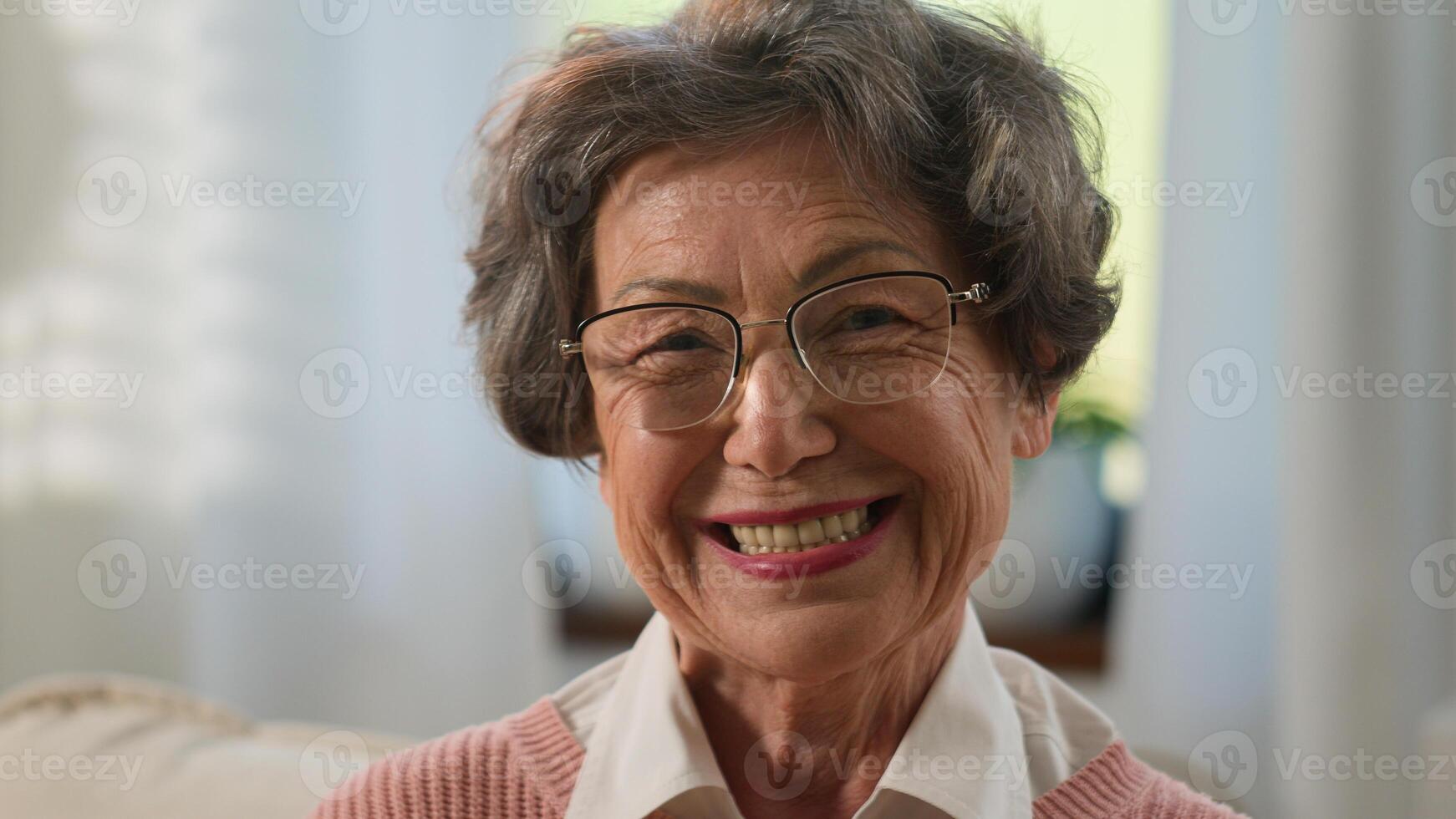 Caucasian pensive beautiful grandmother senior woman looking away cheerful smile at camera at home old mature female elderly granny in glasses medical dementia concept smiling portrait retired lady photo