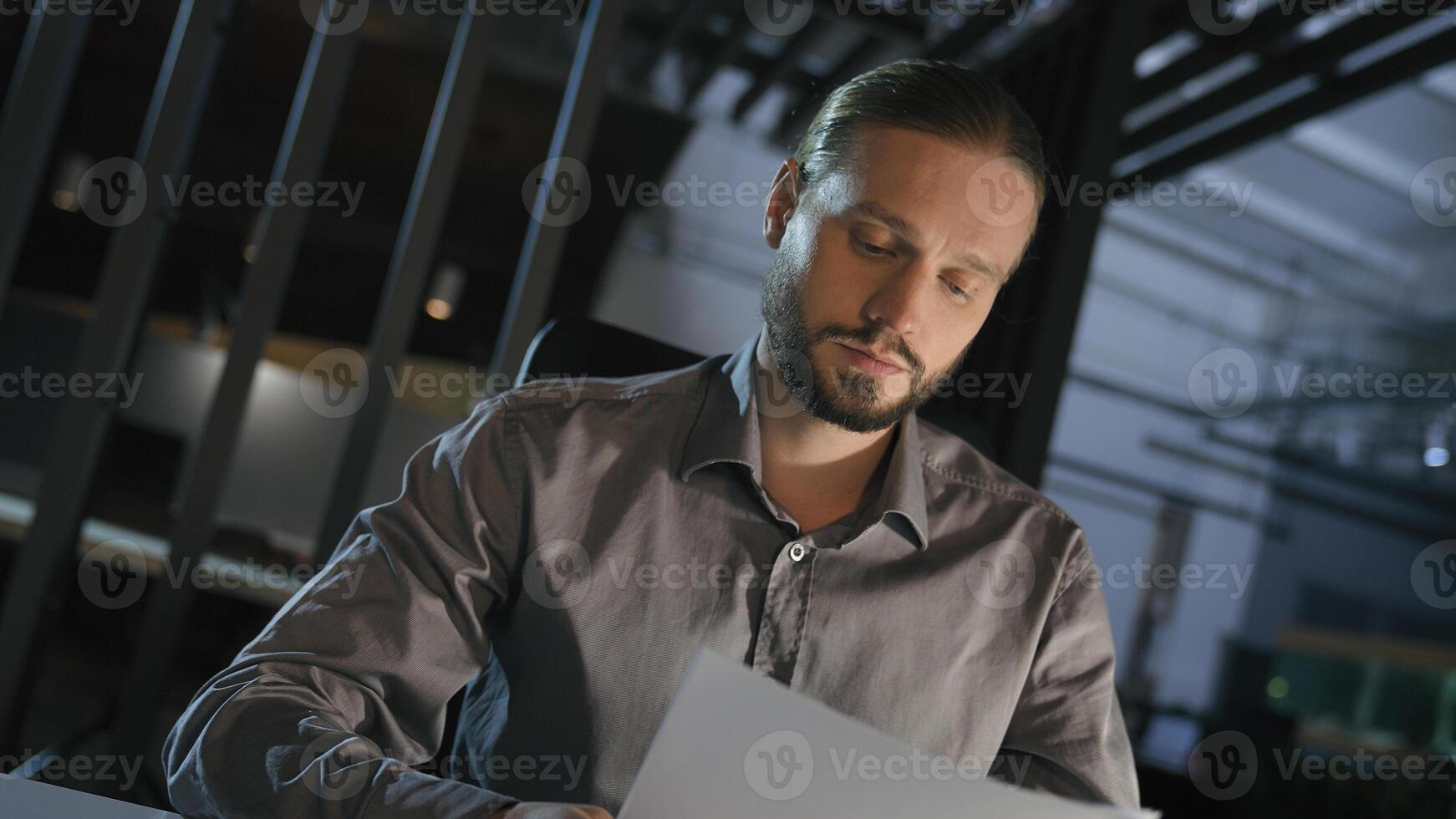 Night evening office sad upset failure angry dissatisfied Caucasian businessman boss with papers document mistake financial problem business trouble man employer late time tired exhausted paperwork photo