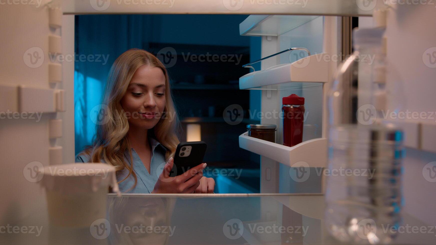 Point of view POV inside refrigerator Caucasian girl hungry woman open fridge at home kitchen look at empty shelves order food products delivery with mobile phone app online service web store shopping photo