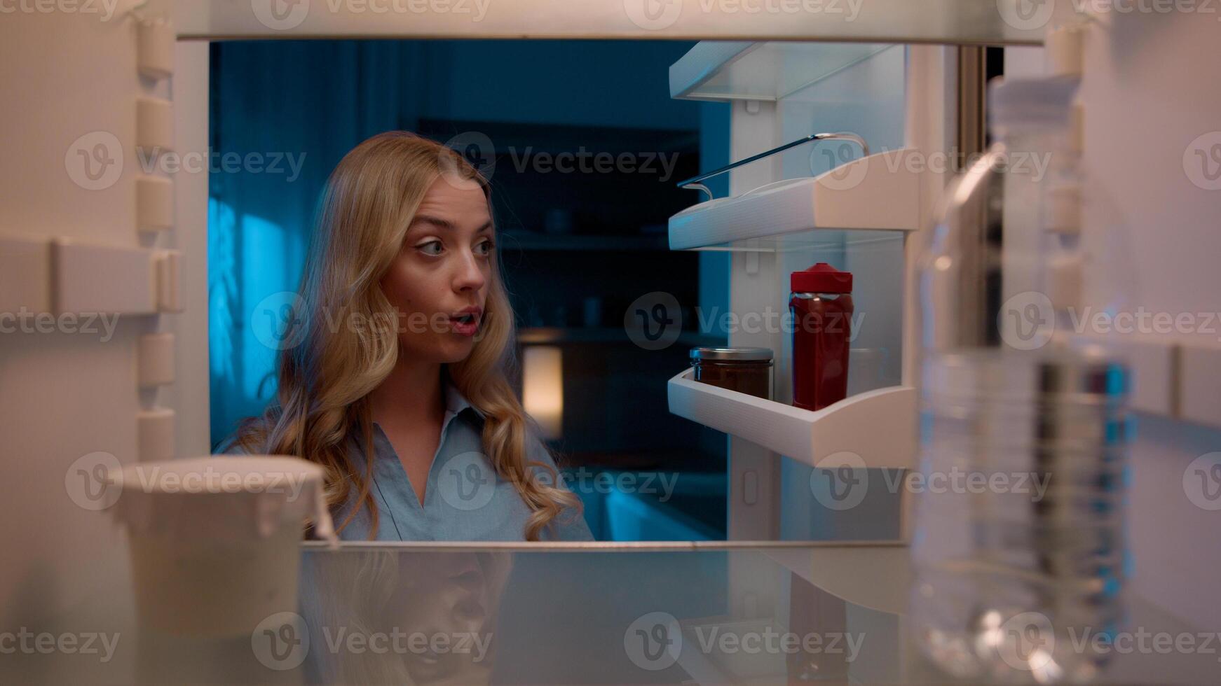 Point of view POV inside refrigerator Caucasian girl hungry woman open fridge at home kitchen look at empty shelves order food products delivery with mobile phone app online service web store shopping photo