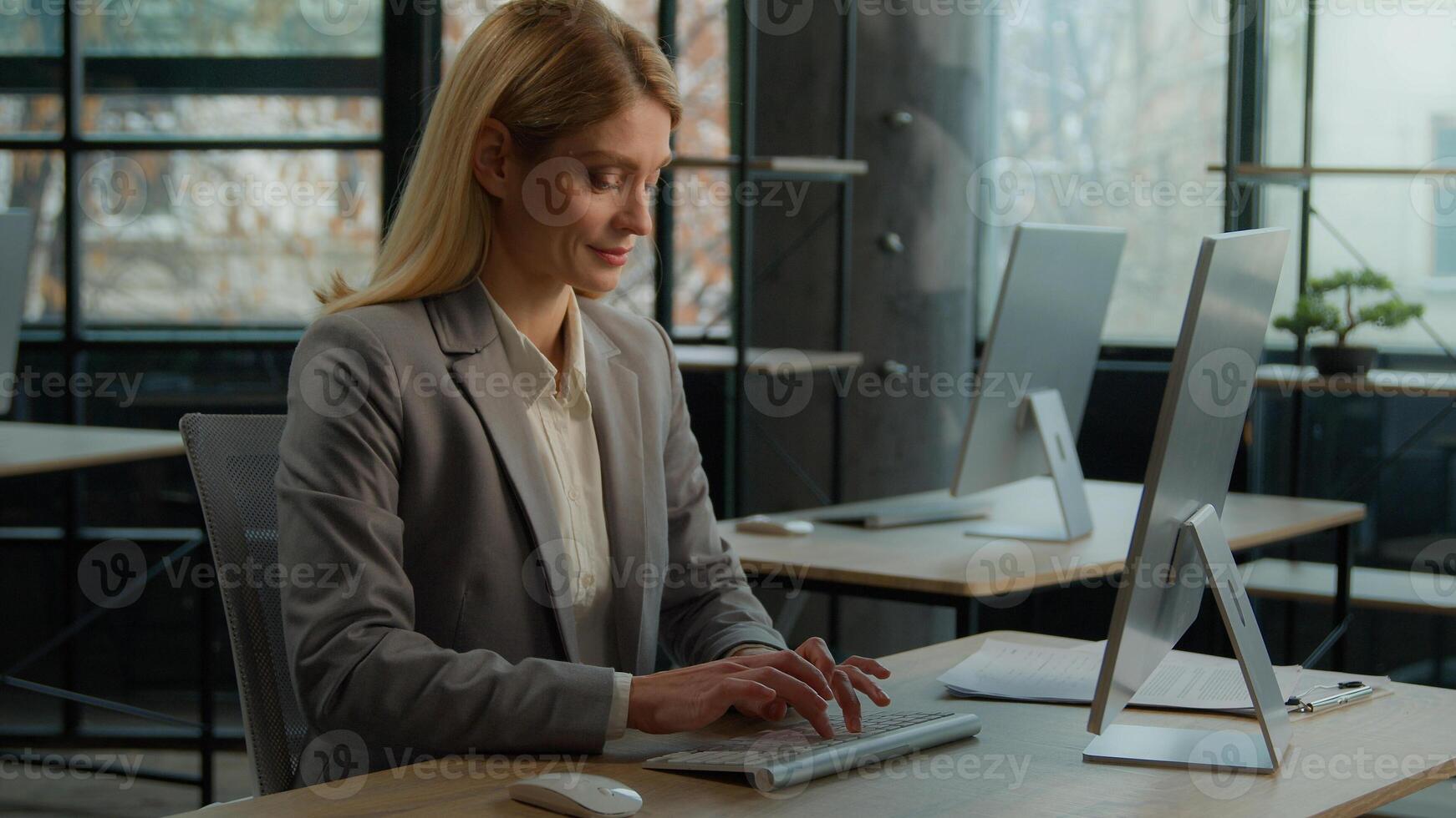 Caucasian 40s woman typing computer online job in office smile enjoy telework internet company working. Businesswoman manager worker using corporate web service executive female chatting with clients photo