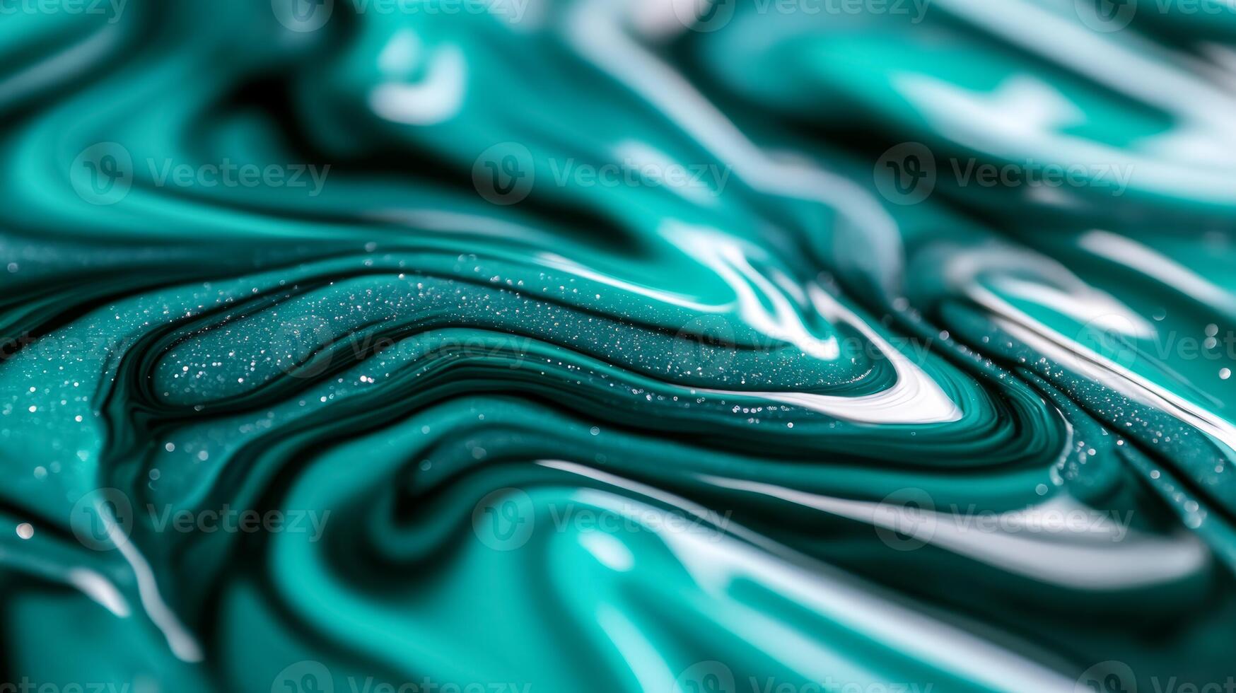 Macro image of waves of blue and green liquid ink merging with hints of glitter photo