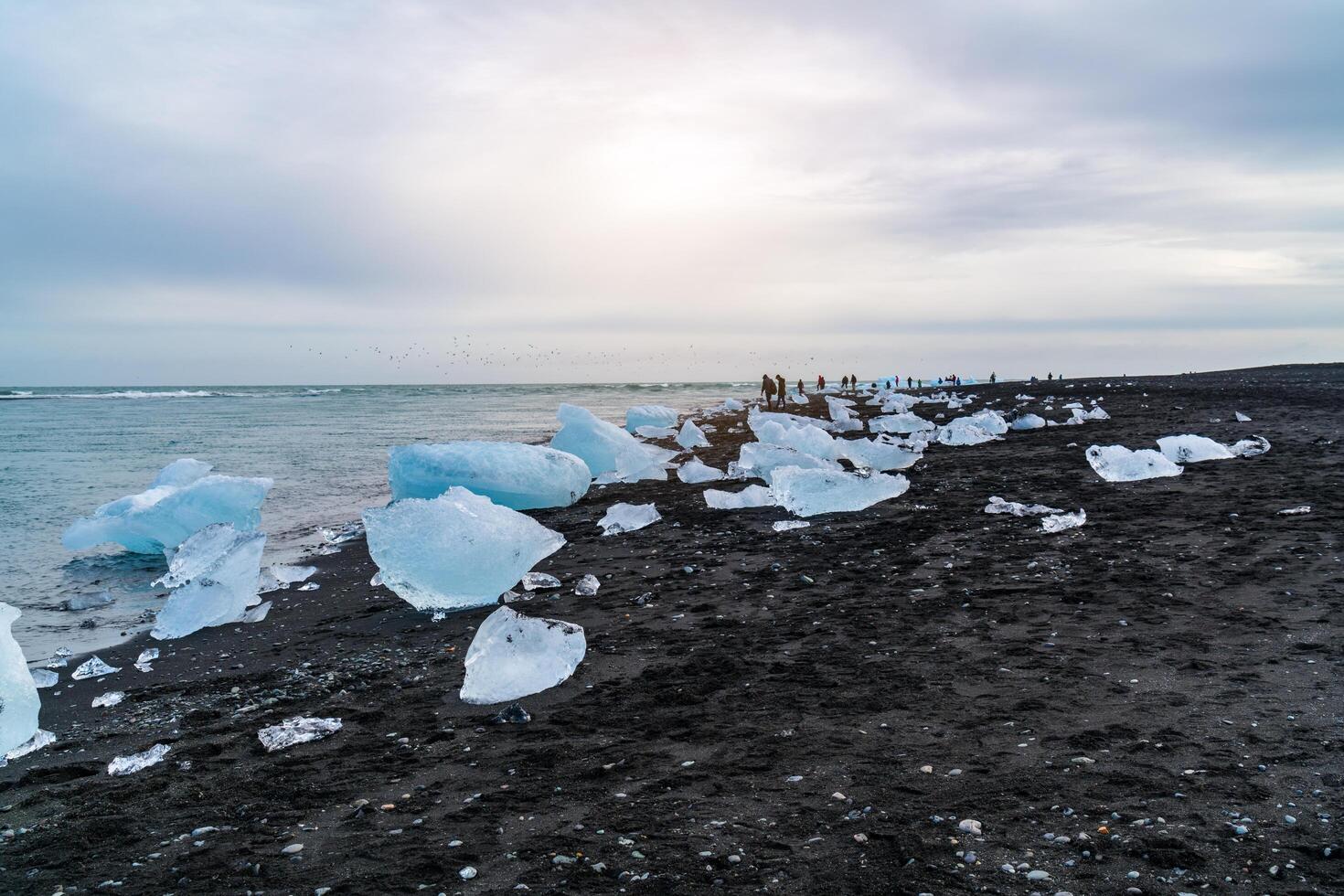 View of ice blocks and tourists on the Diamond Beach. photo