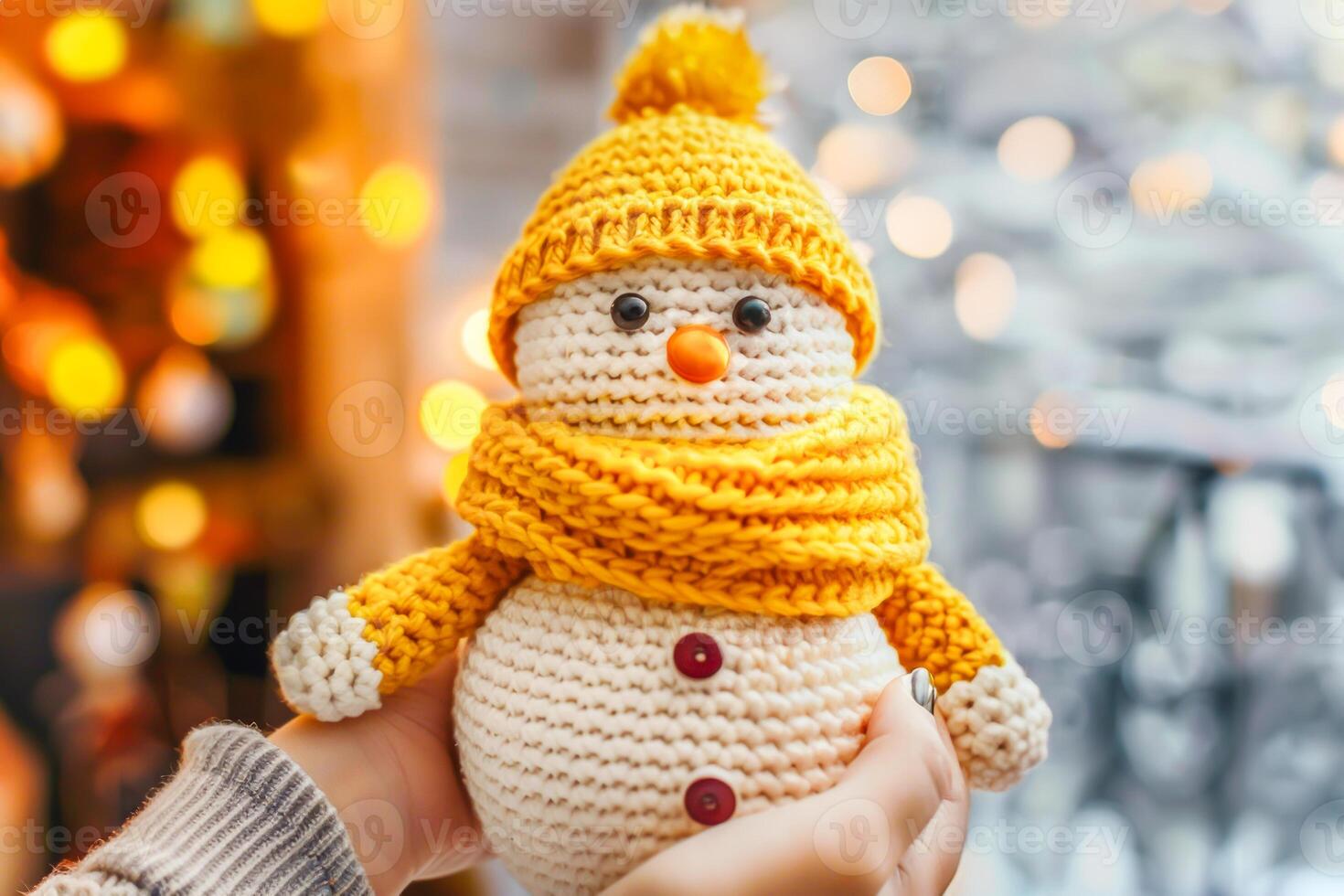 Female hands holding handmade knitted snowman wearing yellow hat and scarf, symbolizing sustainable and eco-friendly Christmas decor. Concept of green Christmas, DIY crafts, and festive creativity photo
