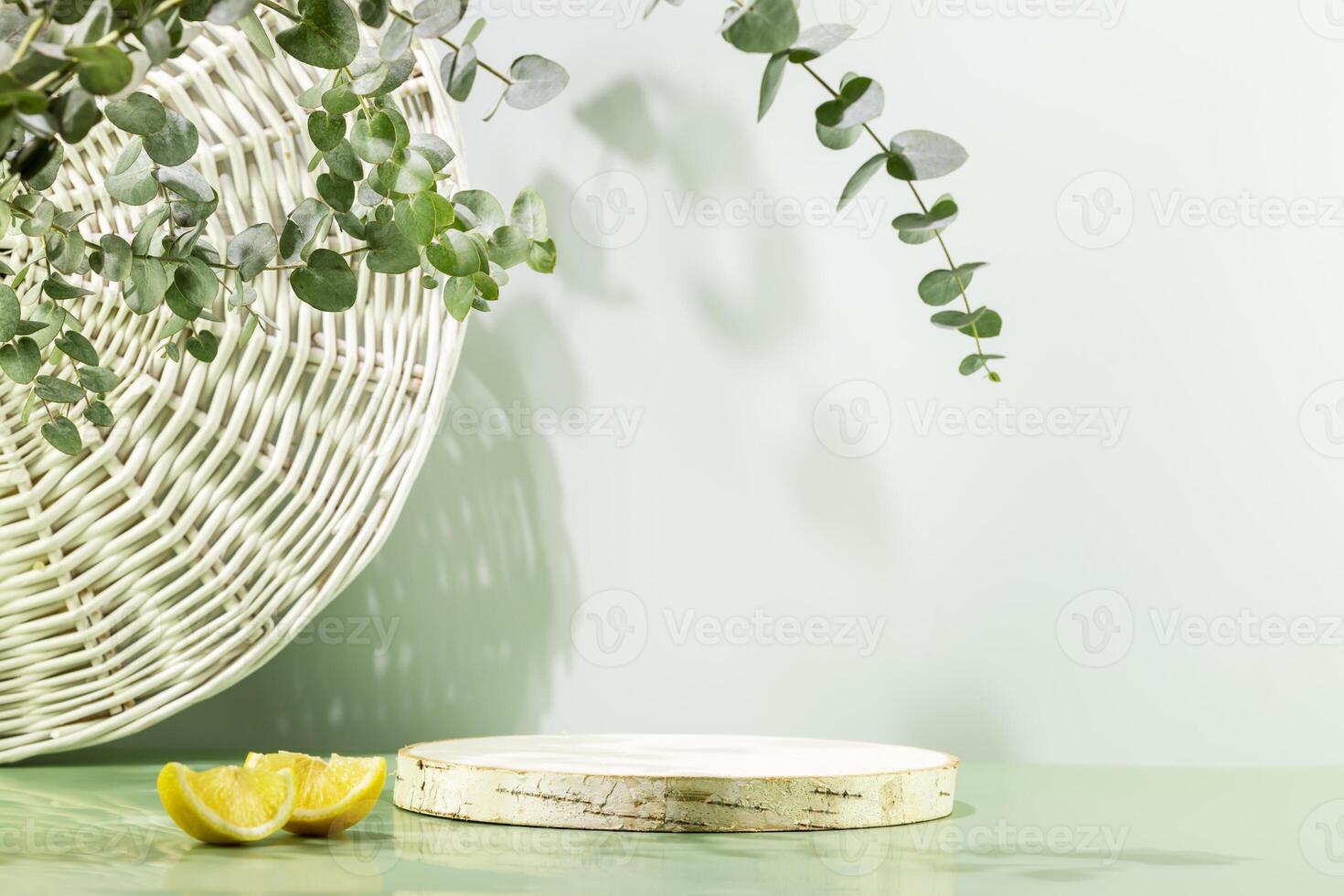 Empty wooden podium with lemon slices on blue background with eucalyptus leave photo