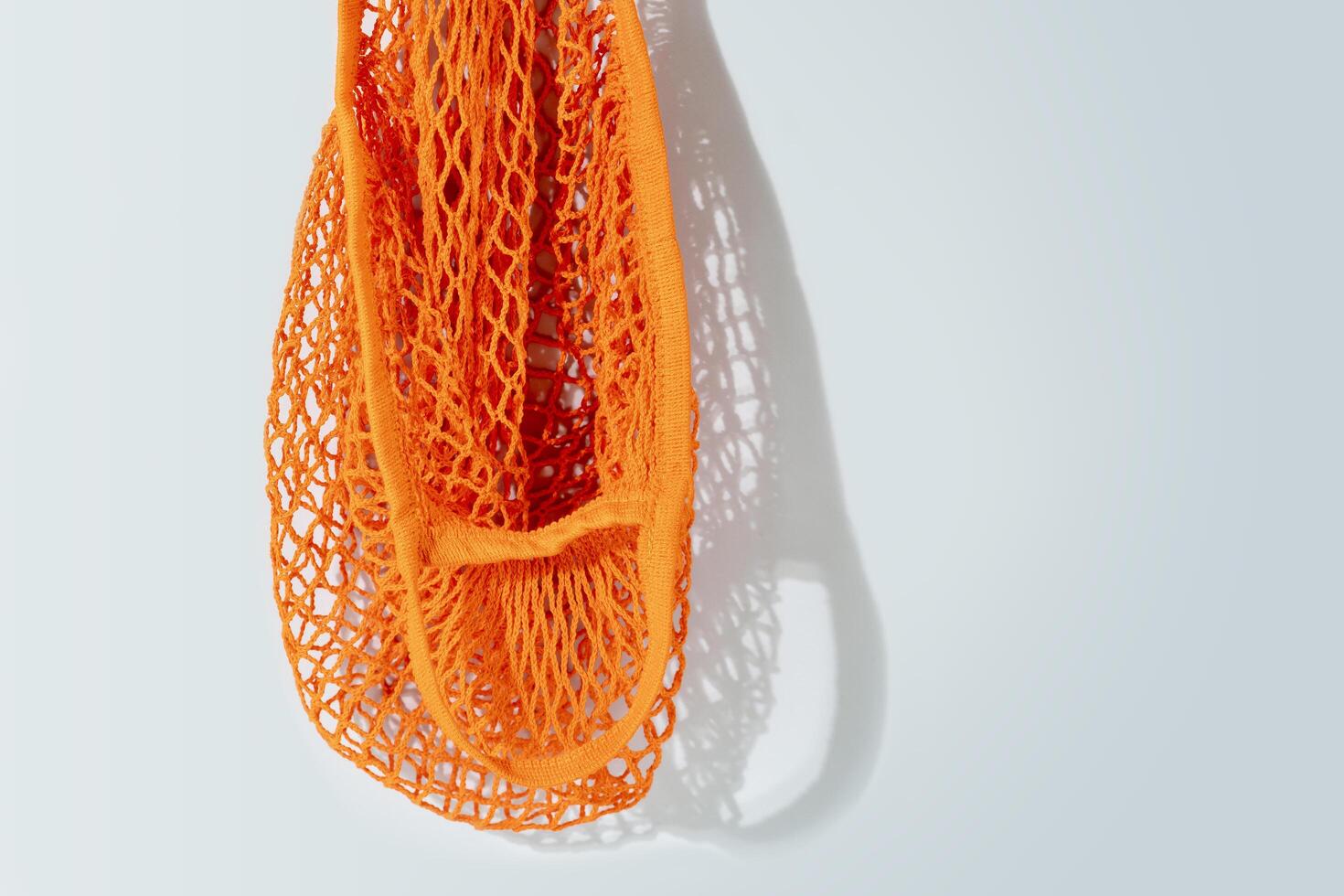 Natural mesh eco bag on blue background with copy space photo