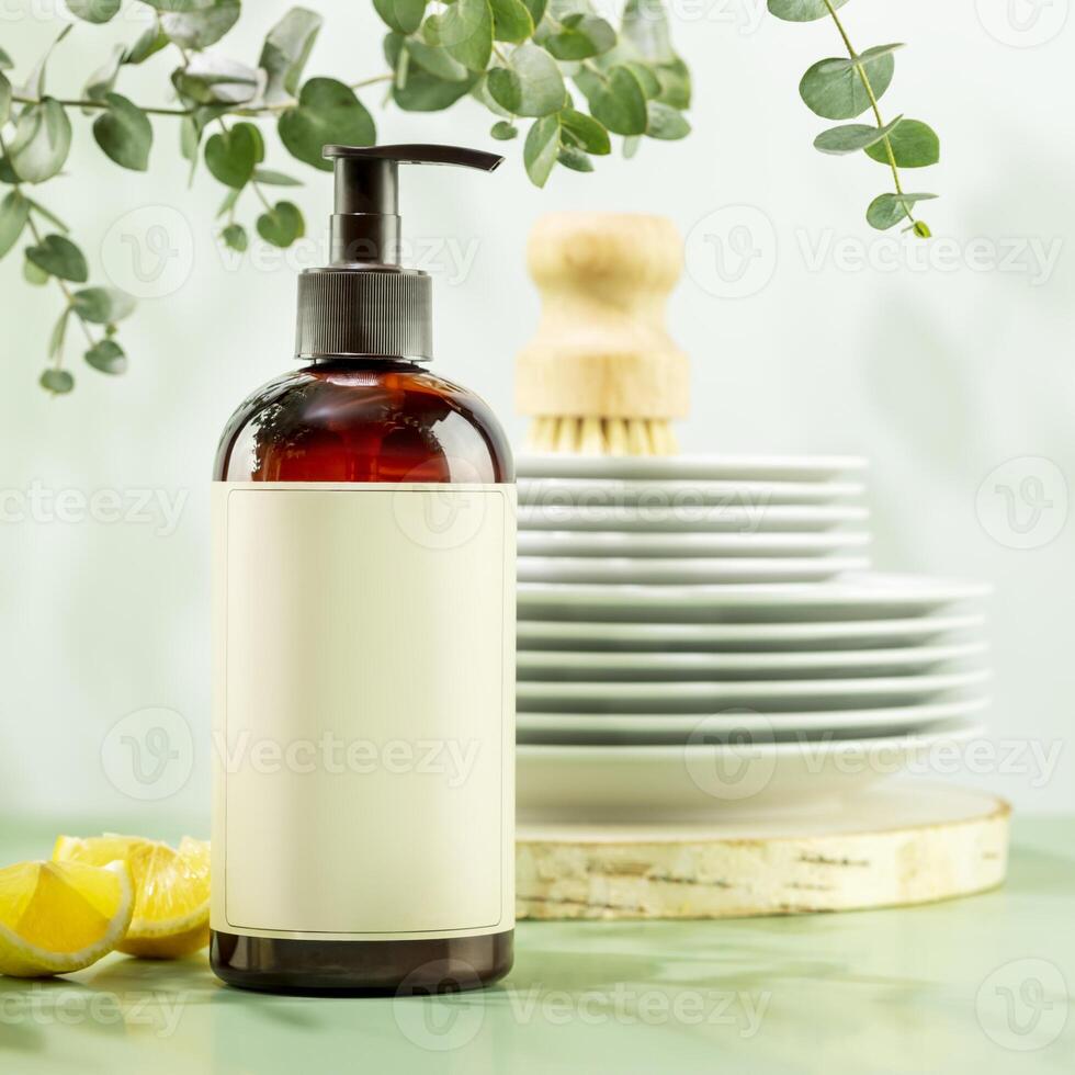 Bottle with dish detergent and clean plates on blue background photo