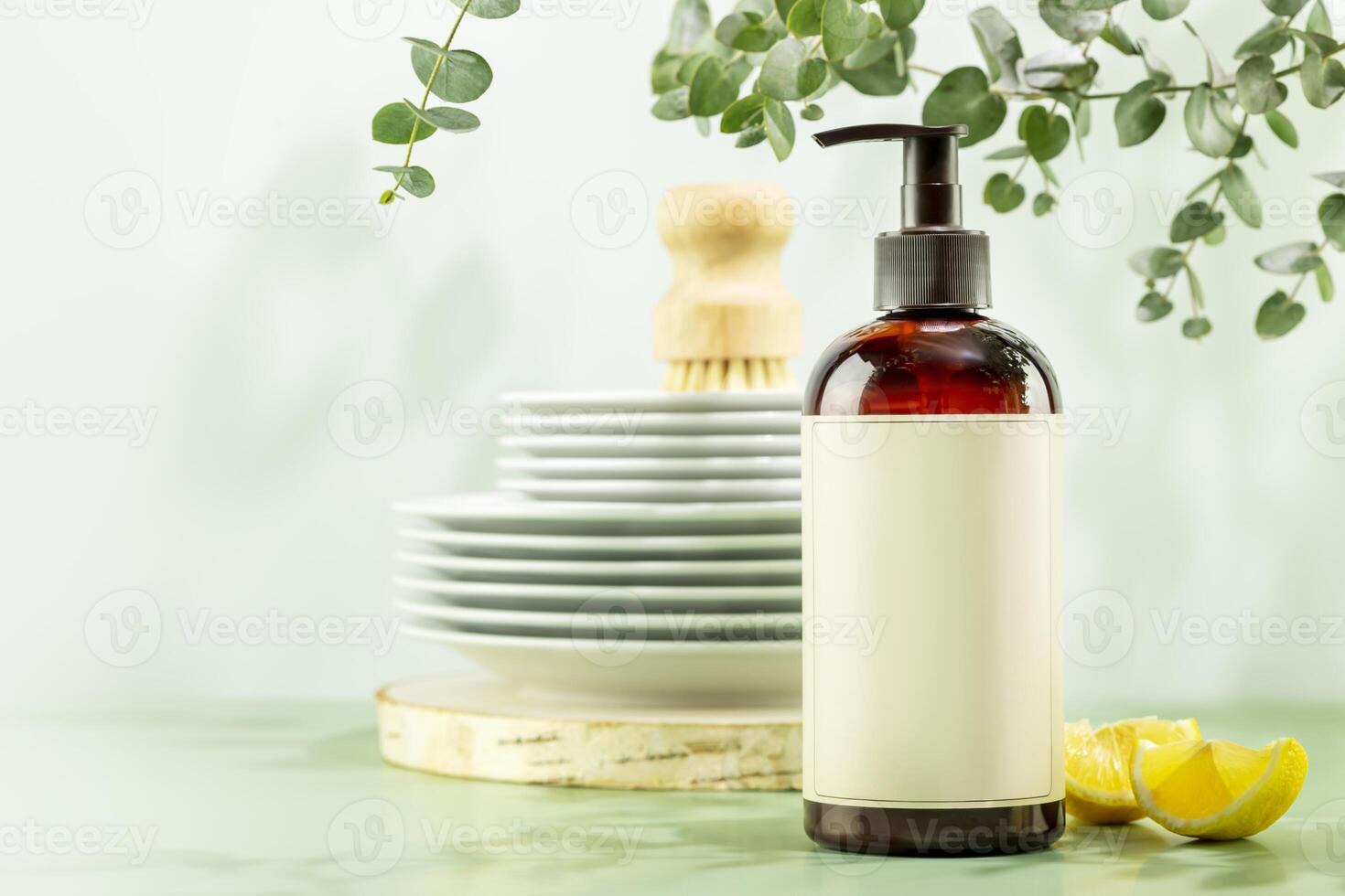 Bottle with dish detergent and clean plates on blue background with copy space photo