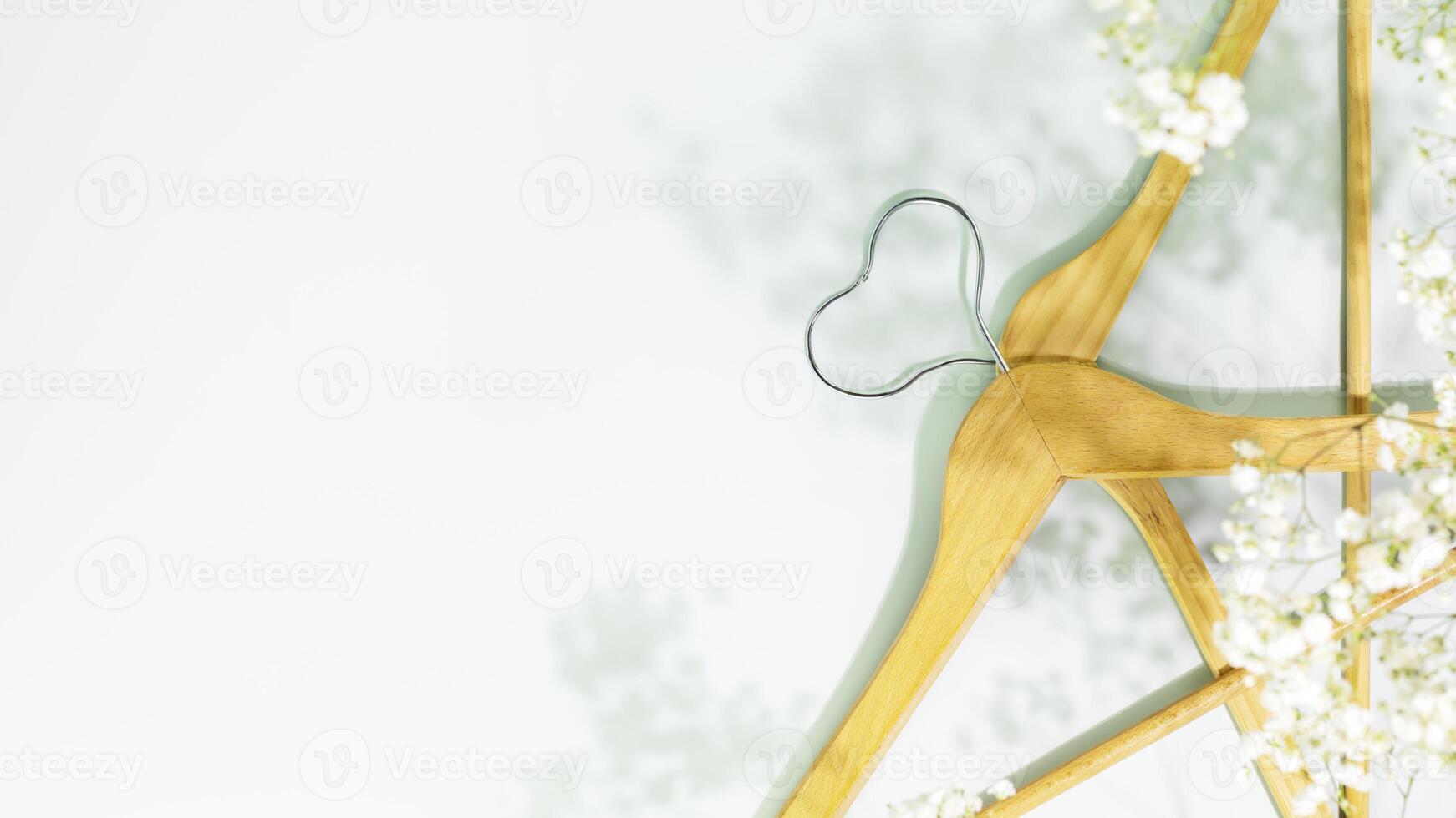 Wooden hangers in shape of heart with white spring flowers with copy space photo