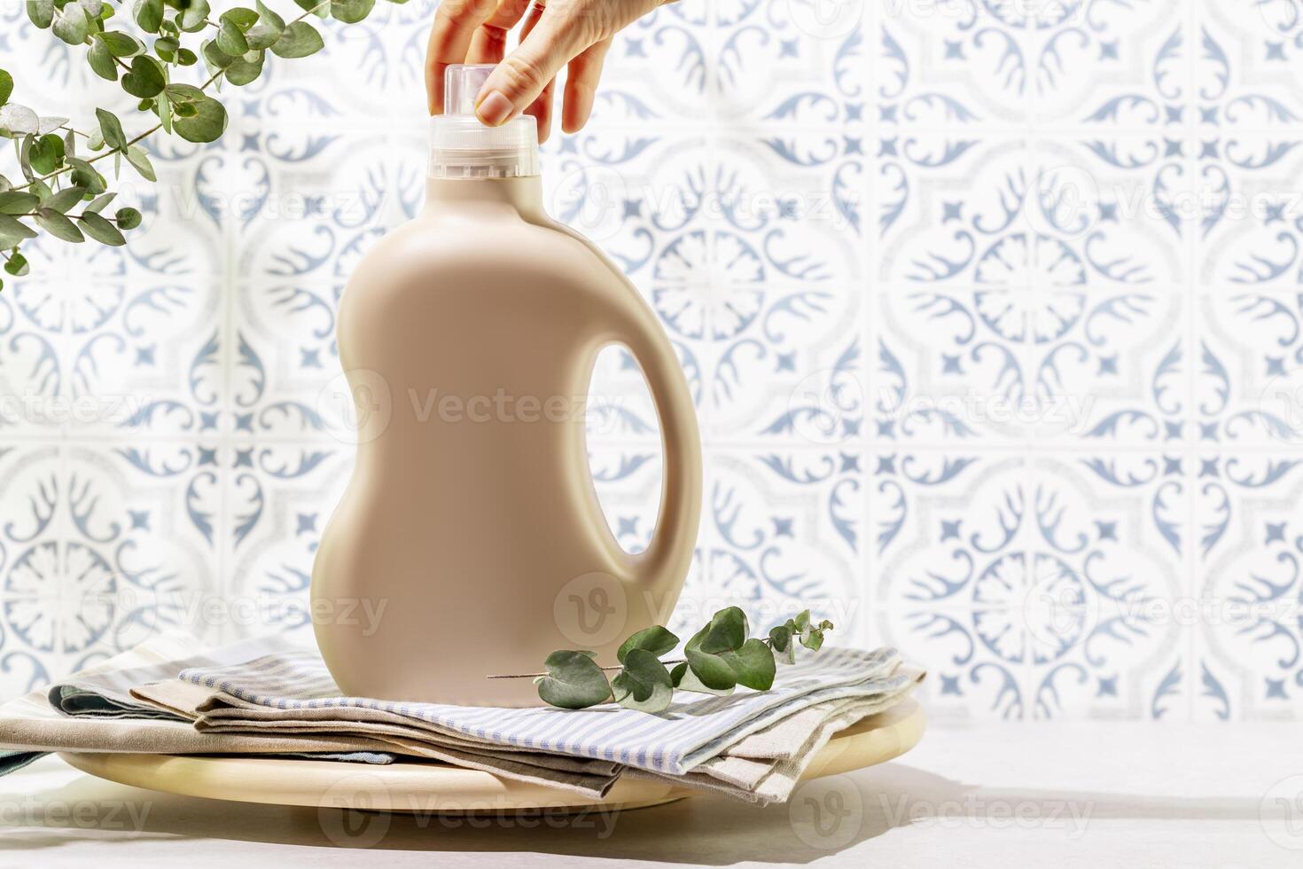 Female hande unscrews the lid from bottle with washing gel on textile napkins photo