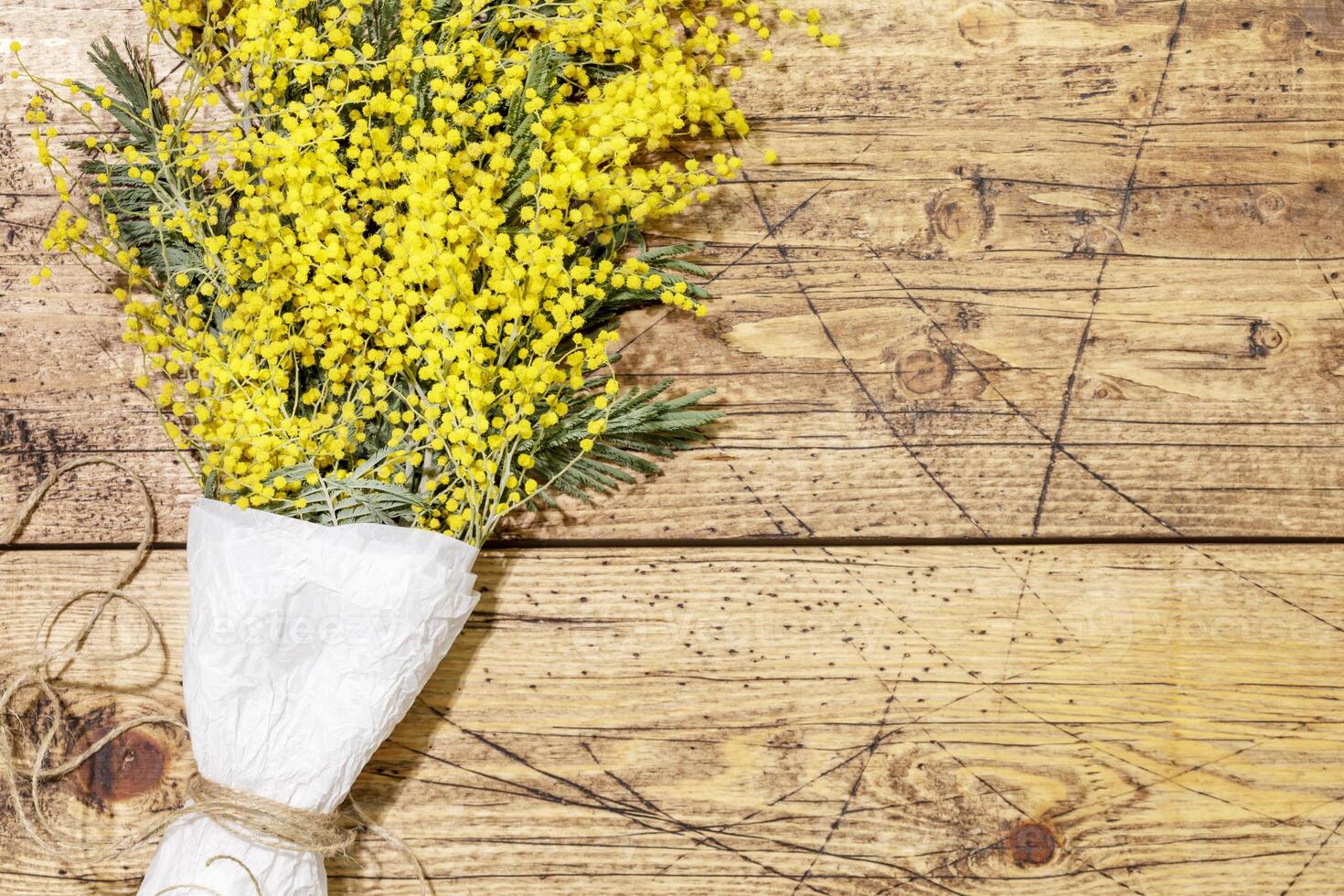 Bouquet with mimosa branches on wooden background photo