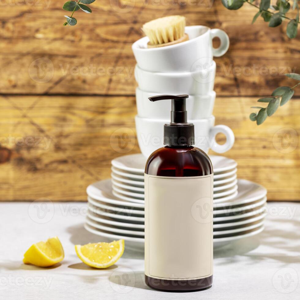 Bottle with dish detergent with clean plates and cups photo