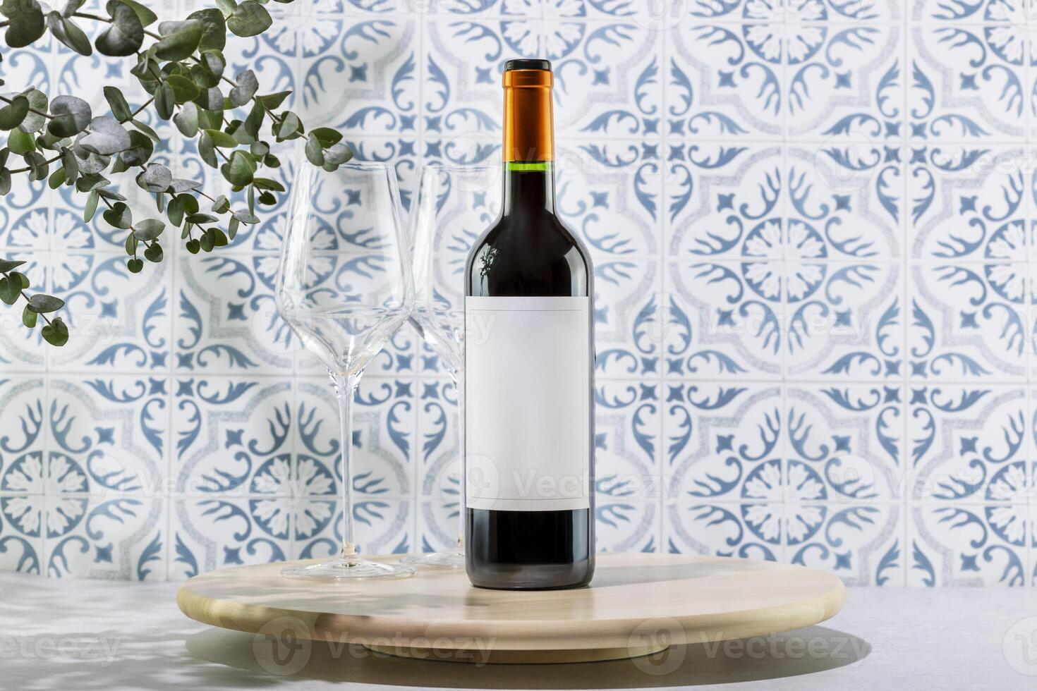 Bottle with red wine on wooden podium opposite tile wall photo