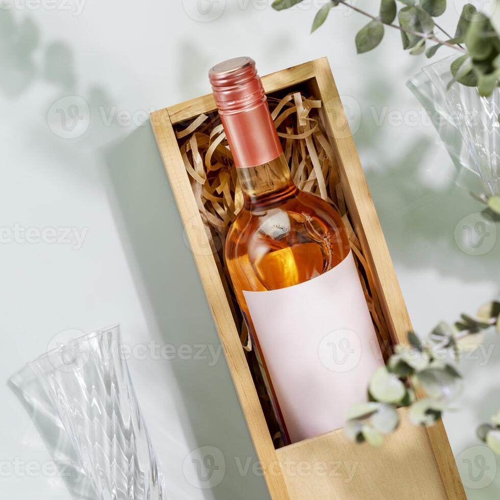 Bottle of natural pink wine with glasses on blue background photo