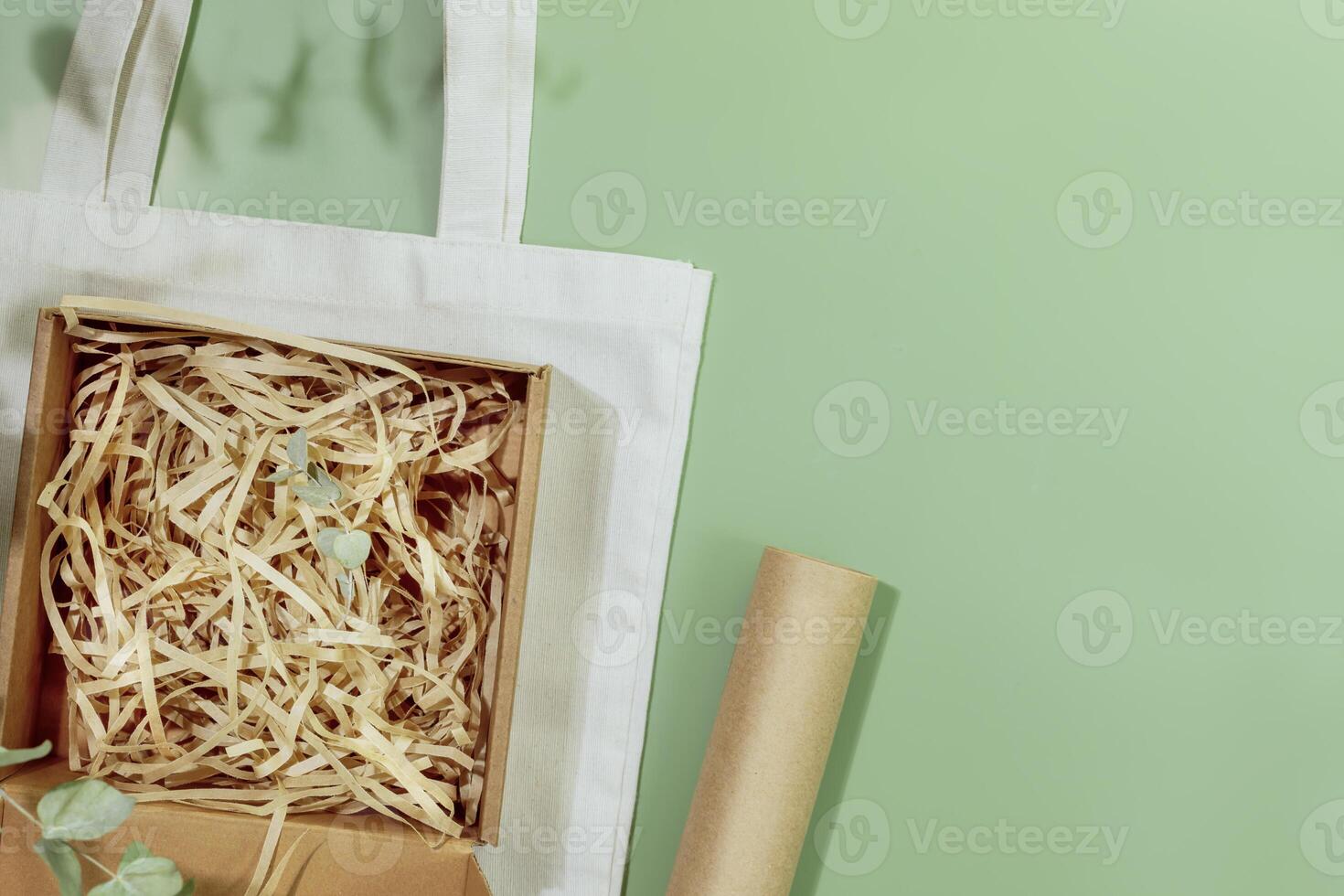 Cardboard box with shredded paper on textile shopping bag with copy space photo