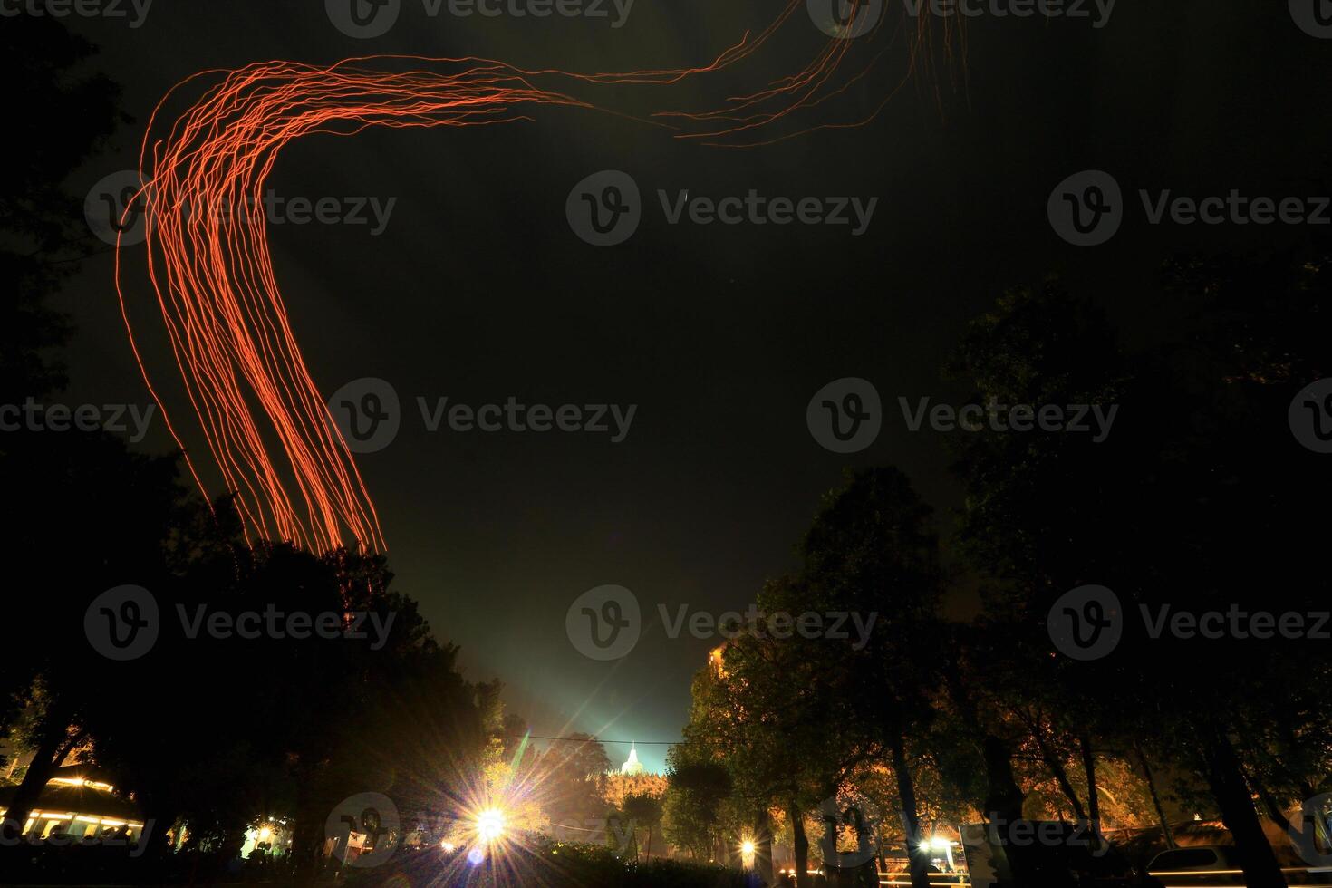 A Red Light Is Flying Through The Night Sky On Borobudur Temple photo