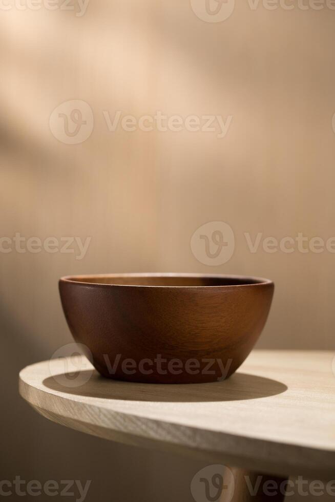 A vertical photograph of a Japanese-style wooden bowl placed on a wooden table, with empty space above for text, intended for advertising purposes. photo
