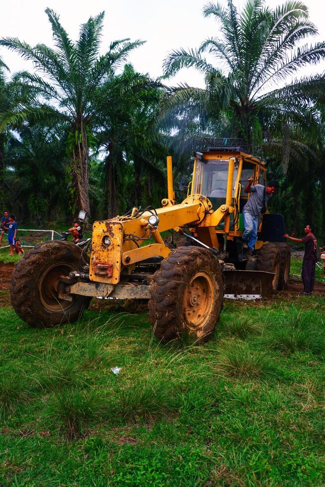 Kalimantan Timur, Indonesia 11 September 2024. The grader machine used to level the road is in operation photo
