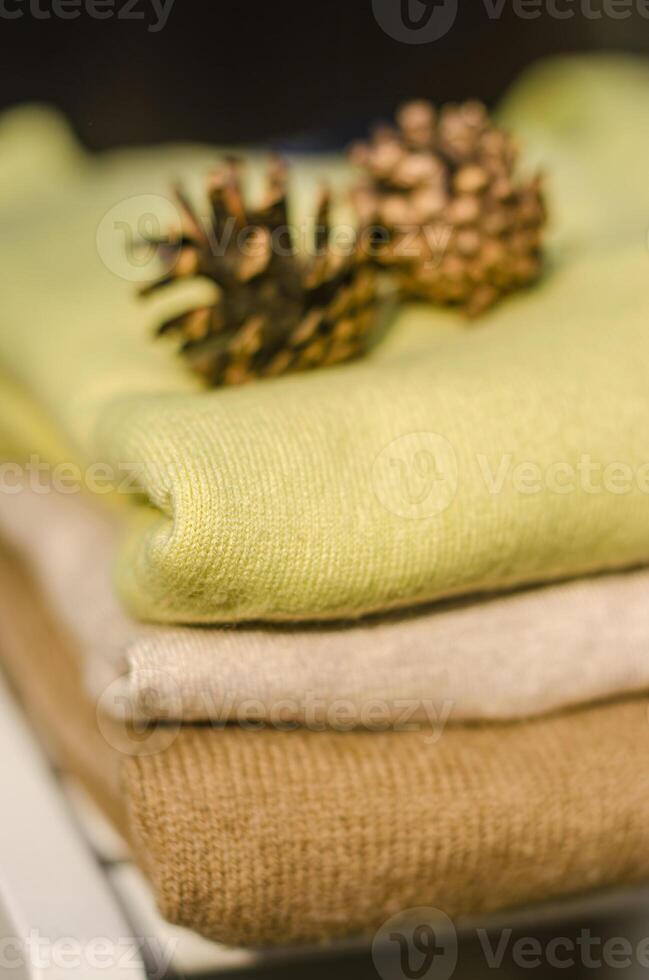 folded green and beige sweaters with cones on top . High quality photo