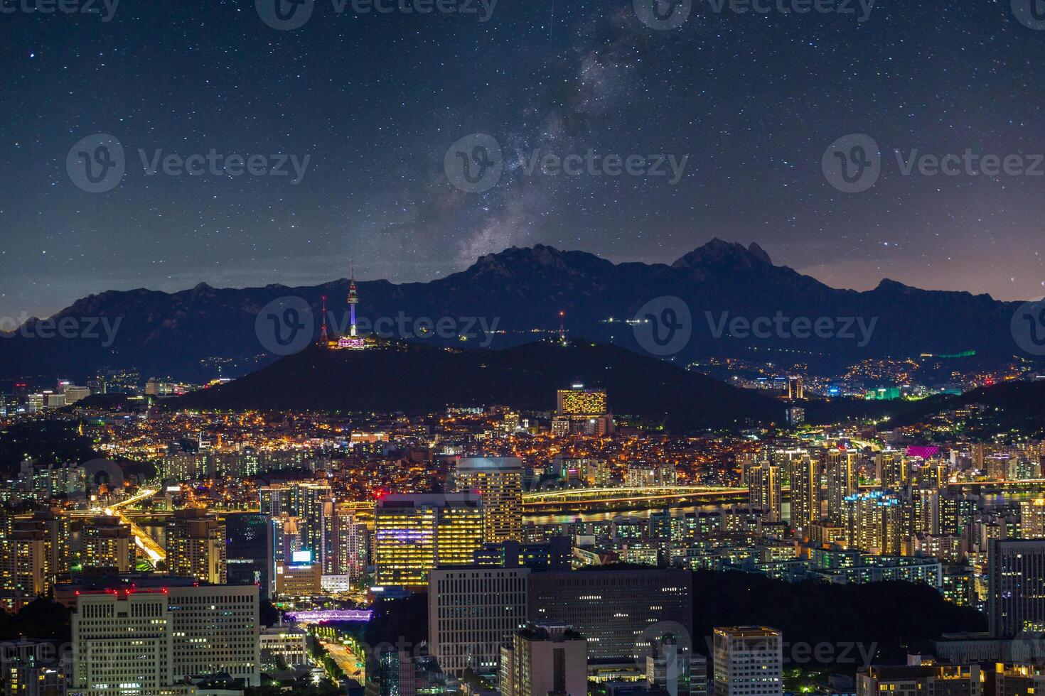 Seoul city skyline and skyscrapers at night with Namsan Mountain and Bukhansan in the background, Seoul, South Korea. photo