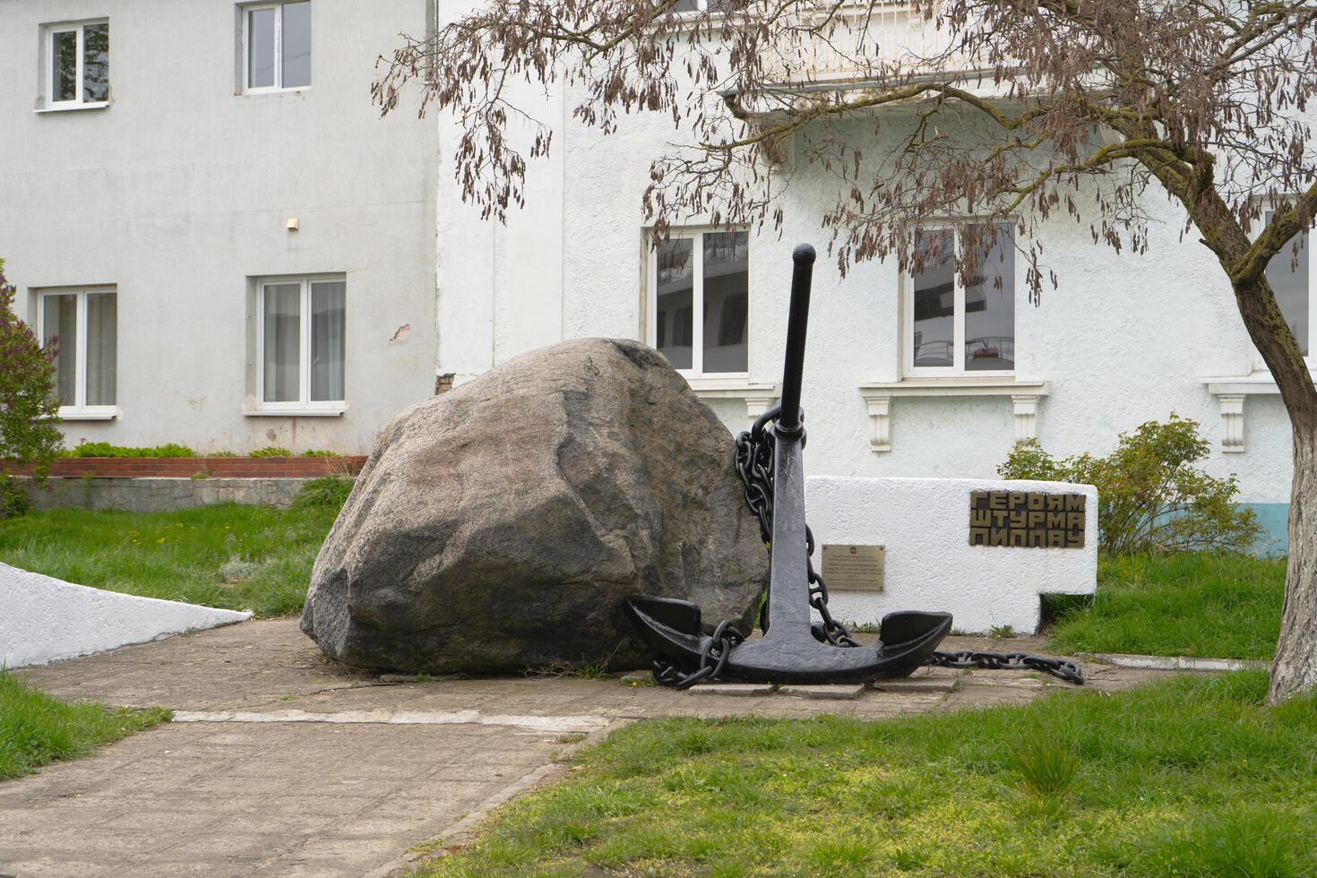 Baltiysk, Russia April 21 2024. Memorial stone to the heroes of the assault on Pillau in Baltiysk. Memorial sign, 25 ton granite boulder with a ships anchor. photo