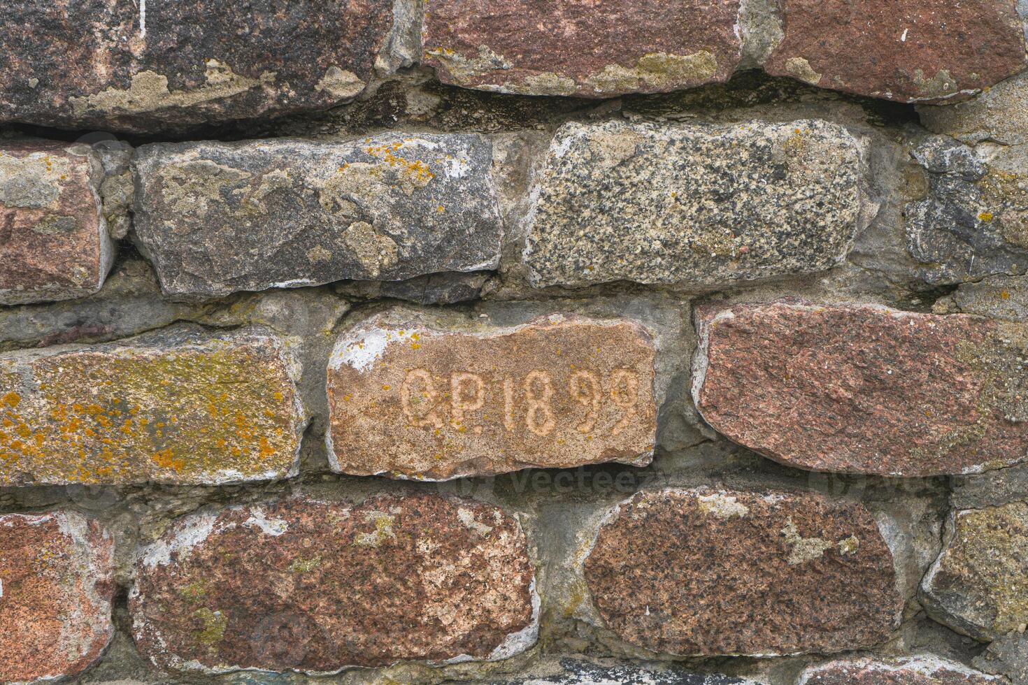 Old brick with inscription O.P. 1899. Part of brick wall. Baltiysk photo