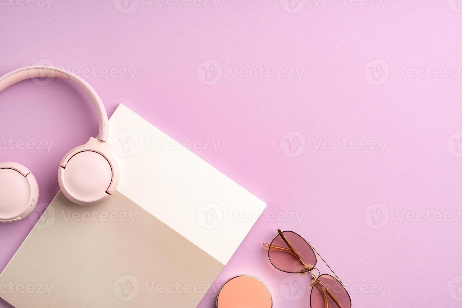Stylish pink headphones and sunglasses on a pastel background photo