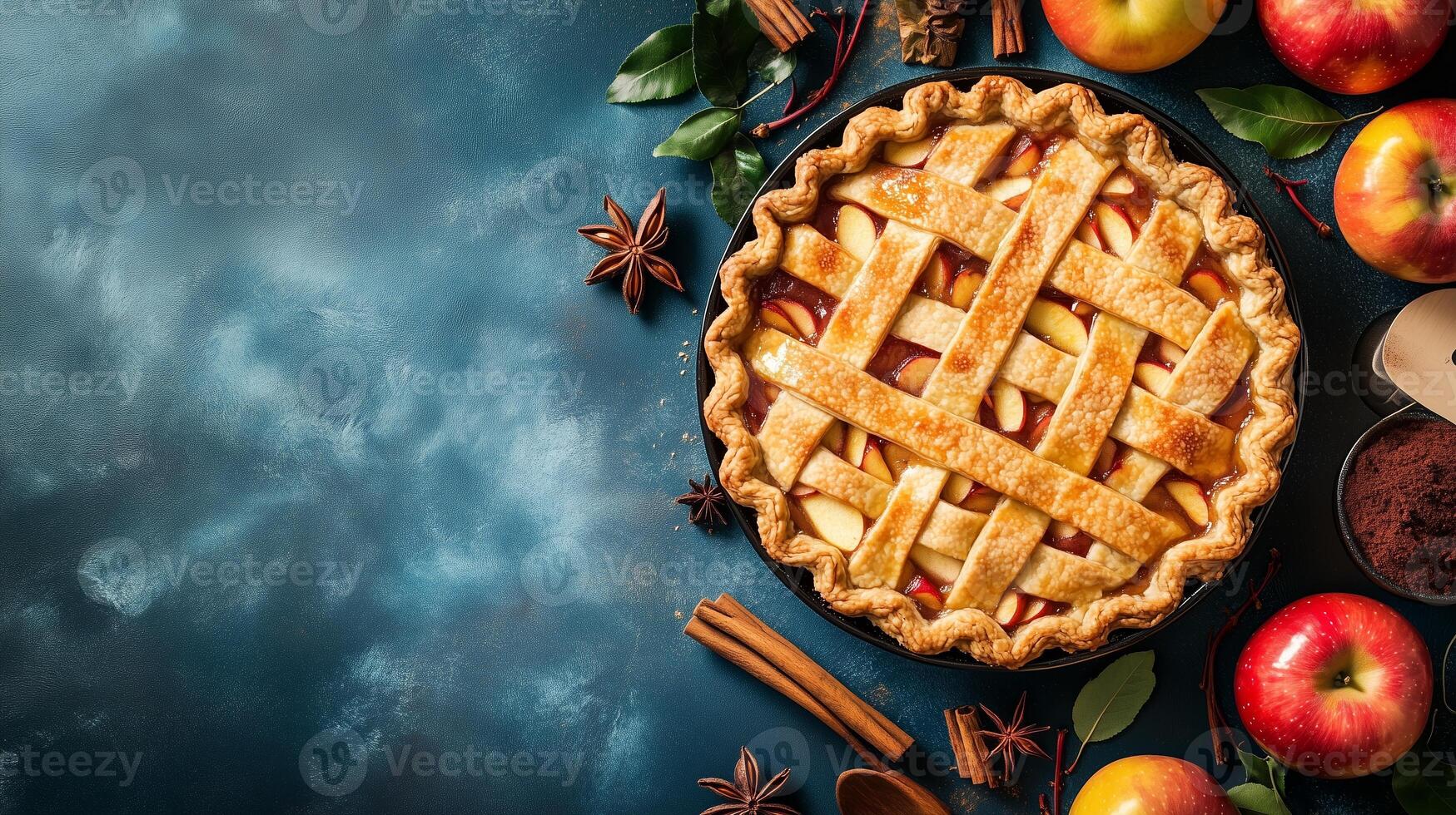 Freshly baked apple pie on a rustic blue background surrounded by spices and fresh apples in autumn photo