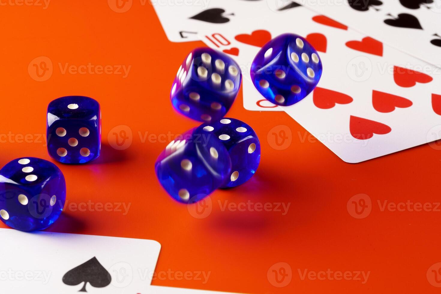 Dice and cards scattered on table close up photo