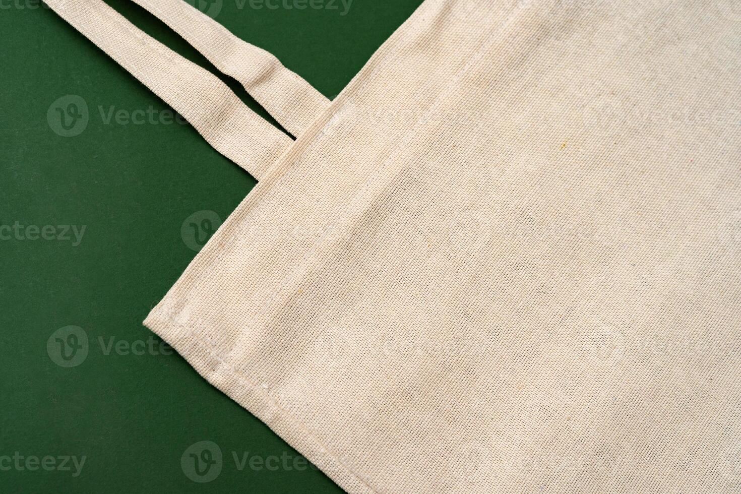 Textile shopping bag on green background flat lay photo